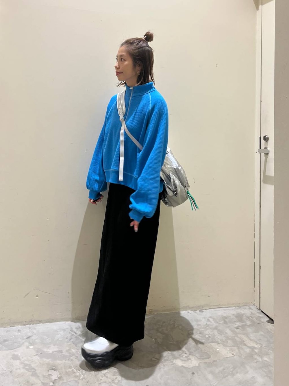 シルバー系のショルダーバッグ、グレー系のブーツ、ブラック系のスカートを着用したレディースの冬コーディネートの5枚目の写真