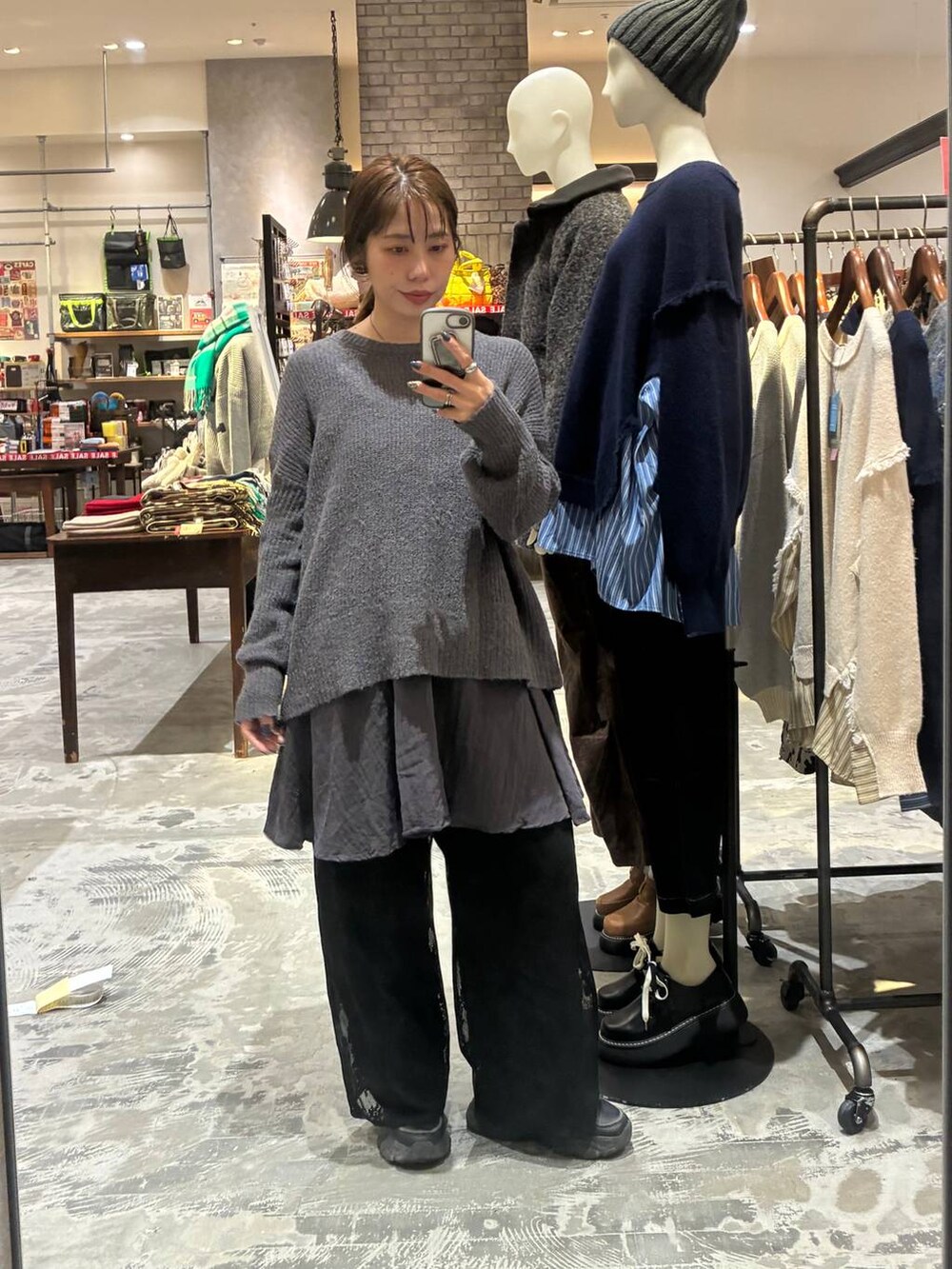 グレー系のニット/セーター、ブラック系のデニムパンツ、ブラック系のその他パンツを着用したレディースの冬コーディネートの2枚目の写真