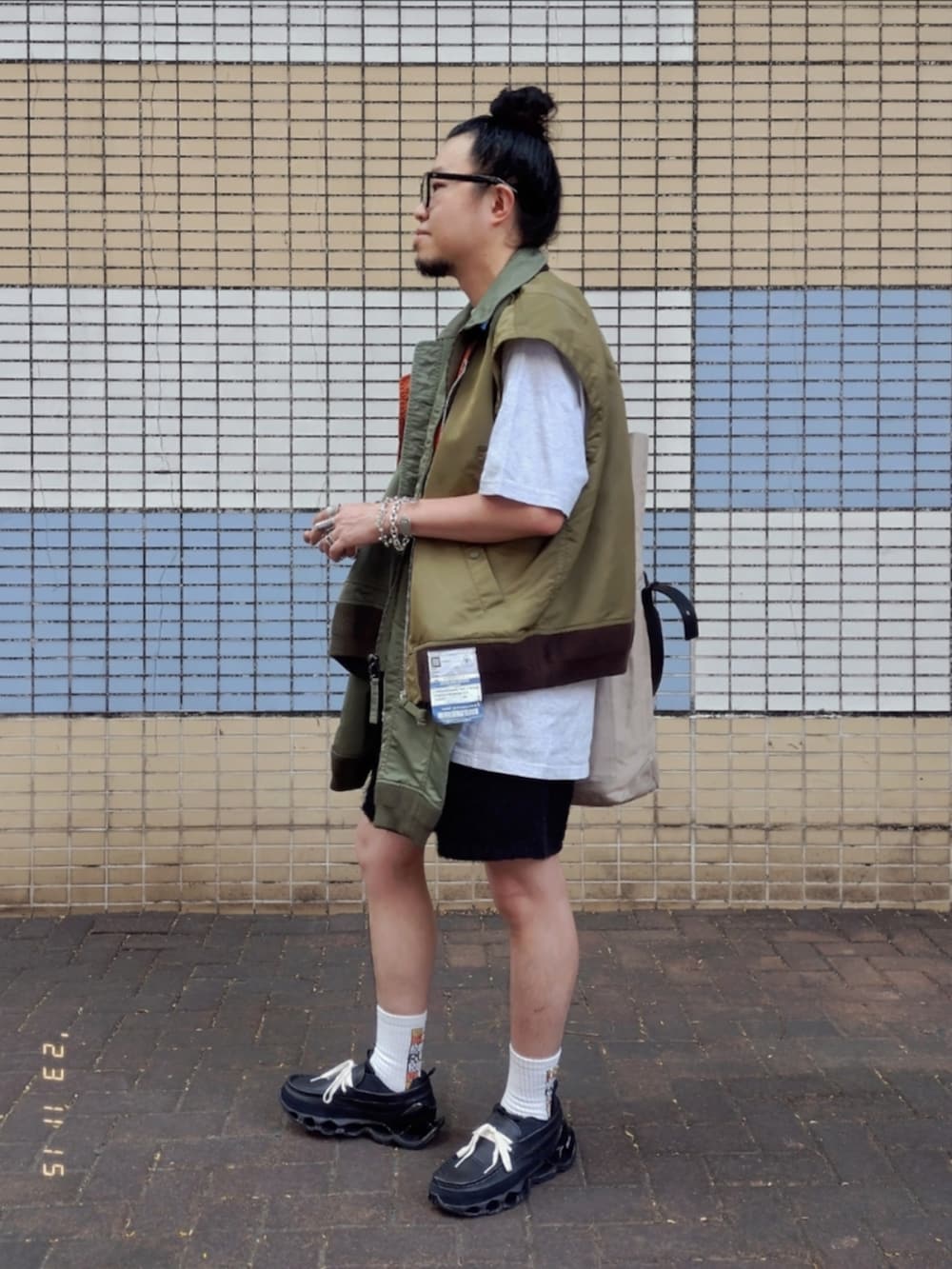 グリーン系のミリタリージャケット、グレー系のTシャツ/カットソー、ブラック系のカーゴパンツを着用したメンズの秋コーディネートの4枚目の写真