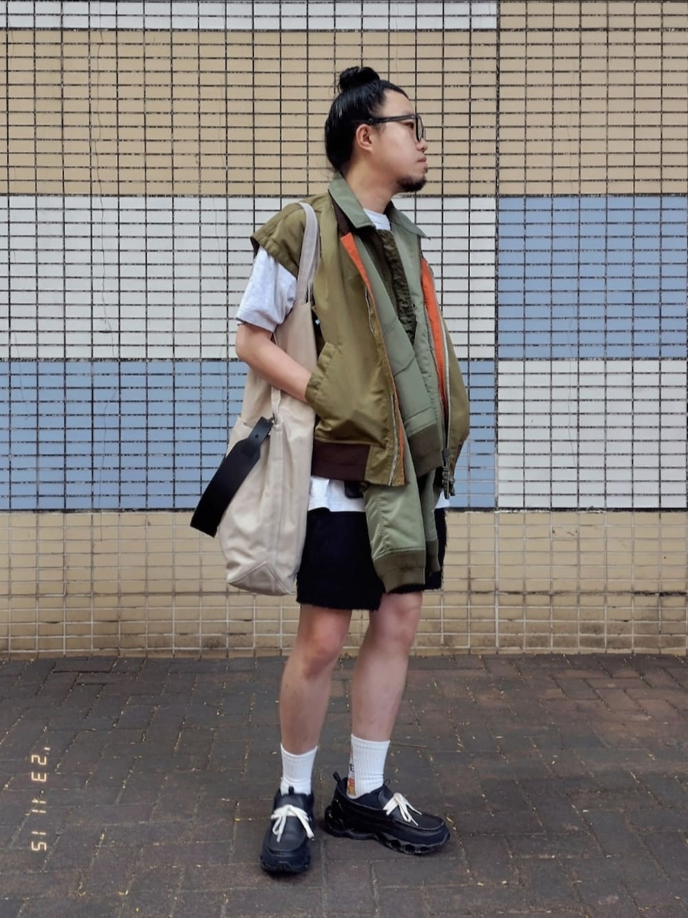 グリーン系のミリタリージャケット、グレー系のTシャツ/カットソー、ブラック系のカーゴパンツを着用したメンズの秋コーディネートの2枚目の写真