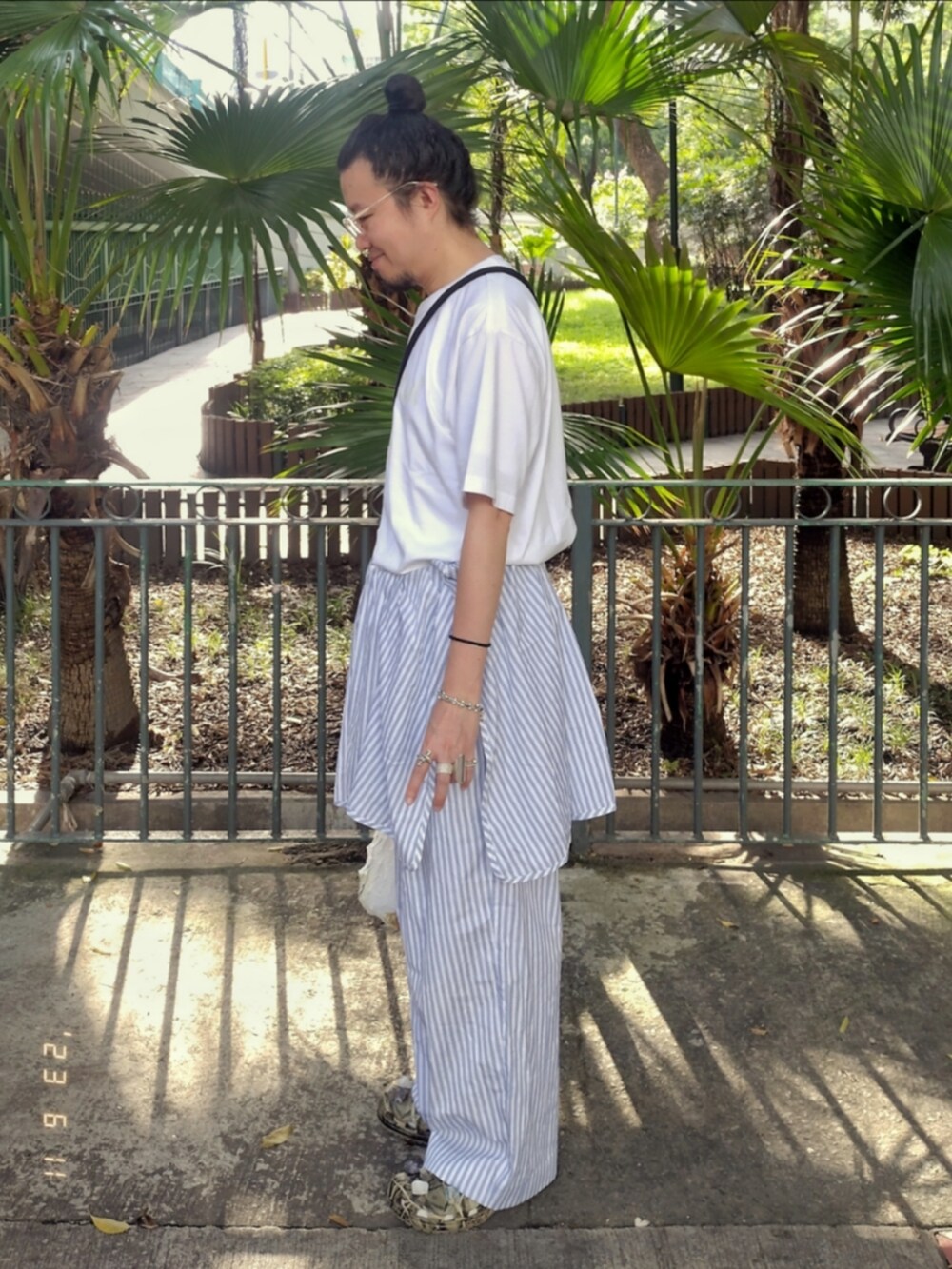 ホワイト系のTシャツ/カットソー、ブルー系のチノパンツ、その他のサンダルを着用したメンズの夏コーディネートの4枚目の写真