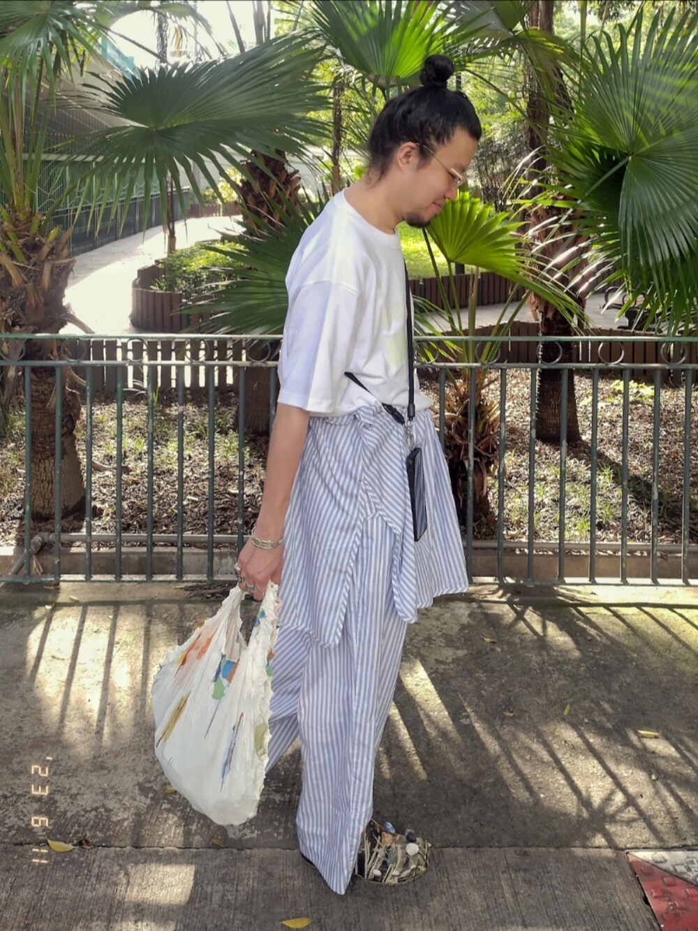 ホワイト系のTシャツ/カットソー、ブルー系のチノパンツ、その他のサンダルを着用したメンズの夏コーディネートの2枚目の写真