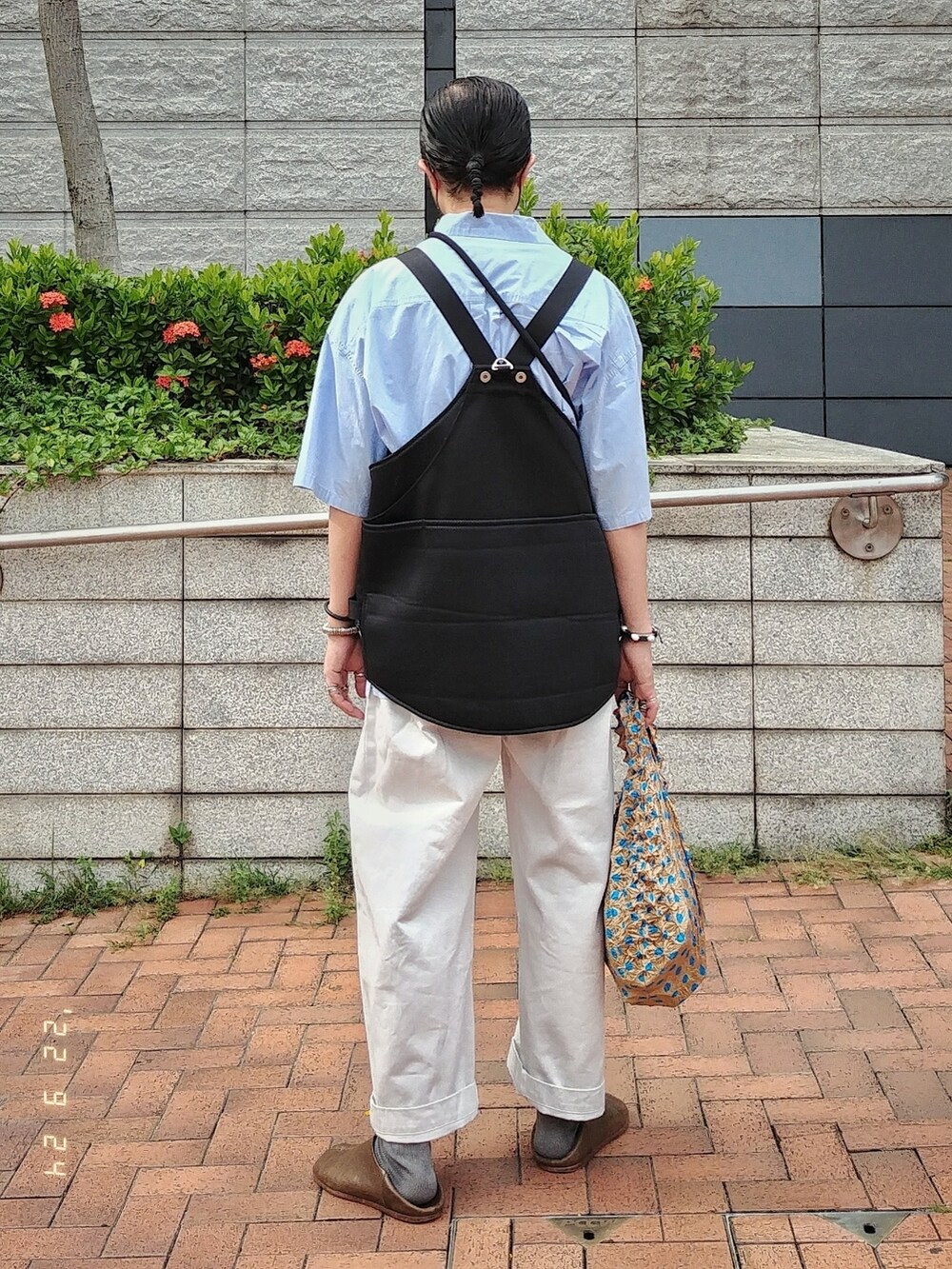 ブラック系のベスト、ブルー系のシャツ/ブラウス、ホワイト系のチノパンツを着用したメンズの秋コーディネートの3枚目の写真