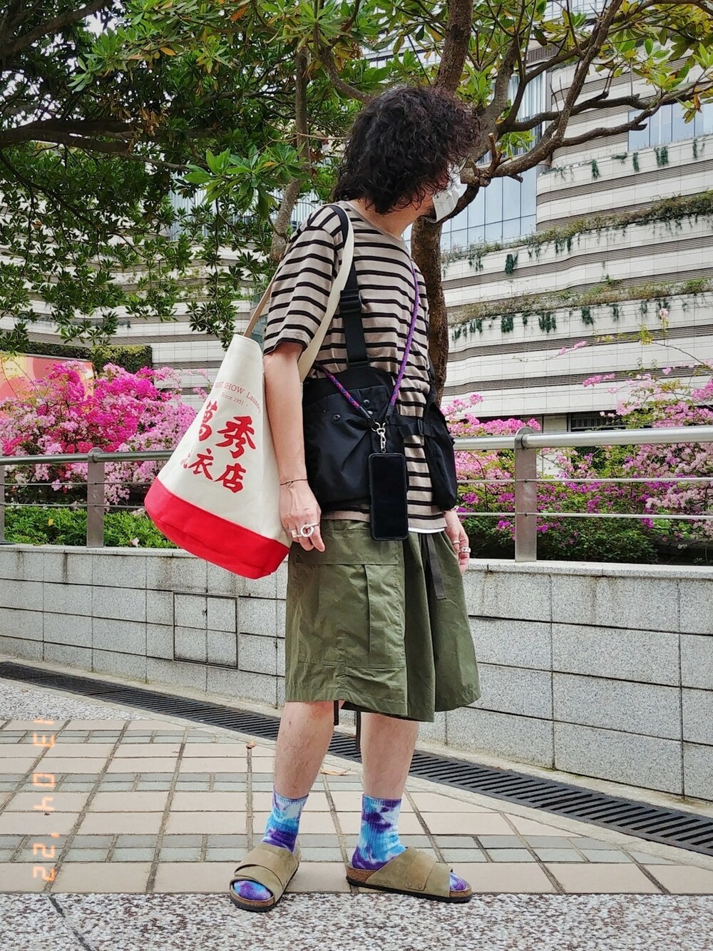 ブラック系のベスト、ブラウン系のTシャツ/カットソー、グリーン系のカーゴパンツを着用したメンズの春コーディネートの2枚目の写真