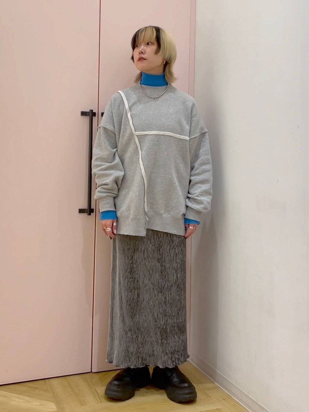 ブルー系のニット/セーター、グレー系のスカート、グレー系のスウェットを着用したレディースの冬コーディネートの4枚目の写真