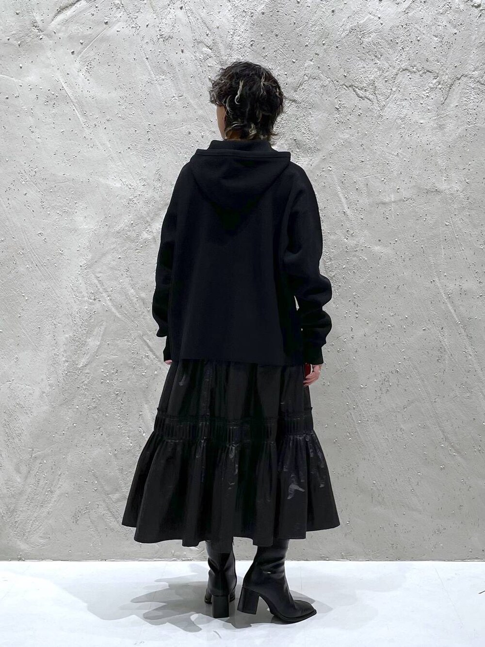 ブラック系のパンプス、ブラック系のニット/セーター、ブラック系のスカートを着用したレディースの秋コーディネートの3枚目の写真