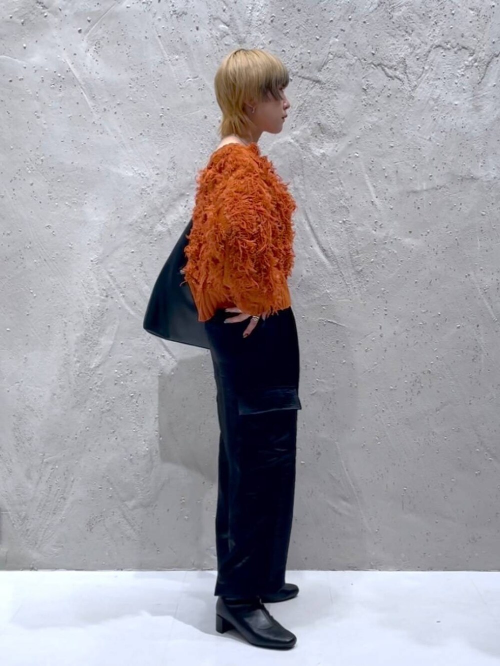 ブラック系のショルダーバッグ、ブラック系のブーツ、ブラック系のカーゴパンツを着用したレディースの秋コーディネートの4枚目の写真