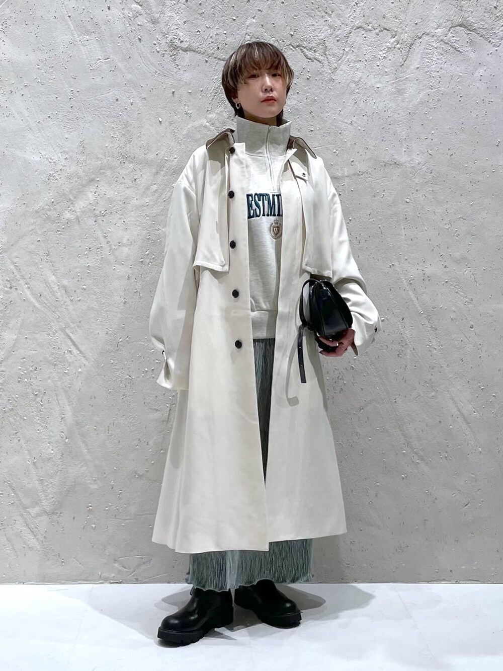 ブラック系のショルダーバッグ、ホワイト系のスウェット、ホワイト系のステンカラーコートを着用したレディースの秋コーディネートの4枚目の写真