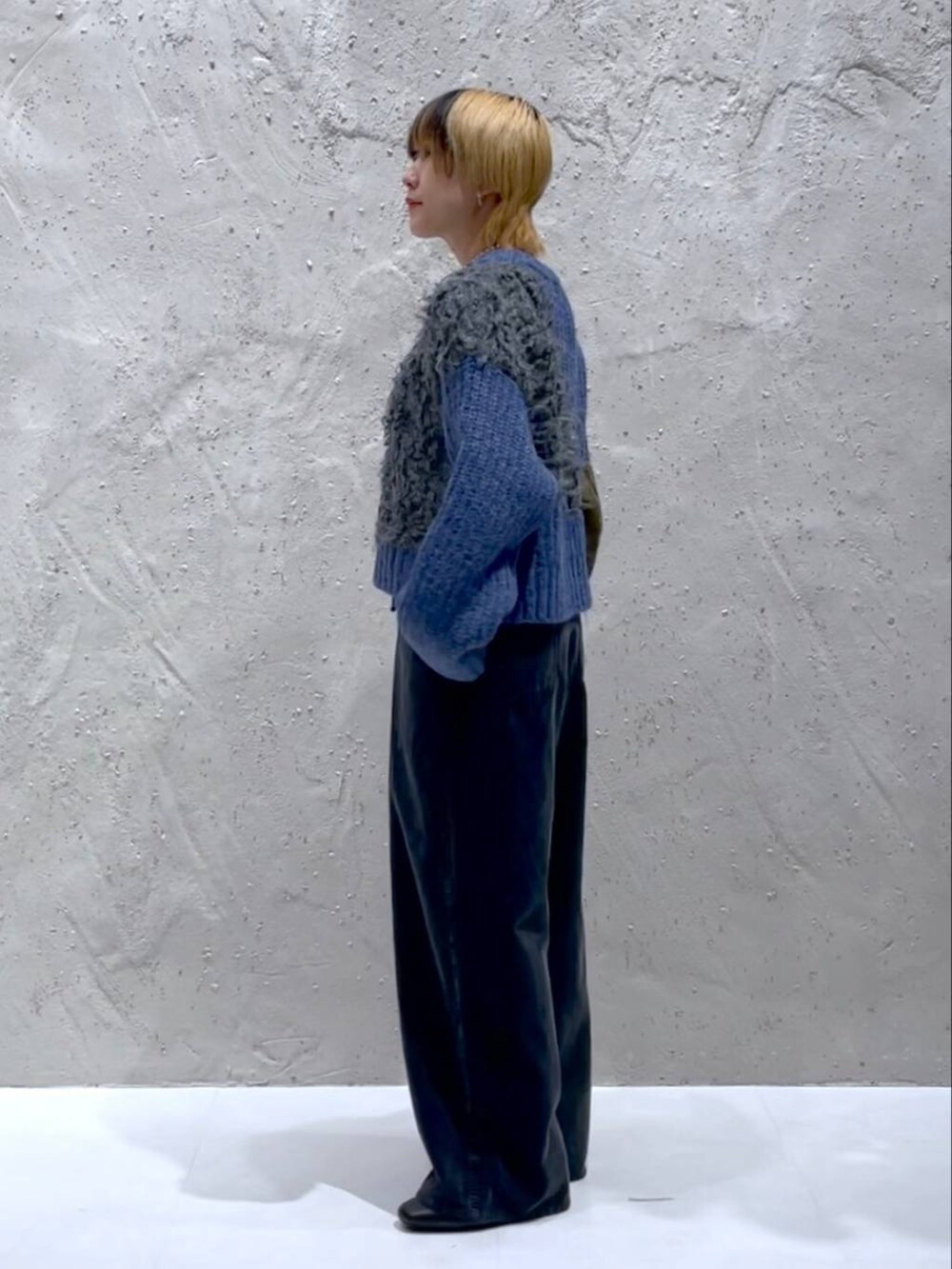 ブラック系のブーツ、ブルー系のニット/セーター、イエロー系のショルダーバッグを着用したレディースの秋コーディネートの4枚目の写真