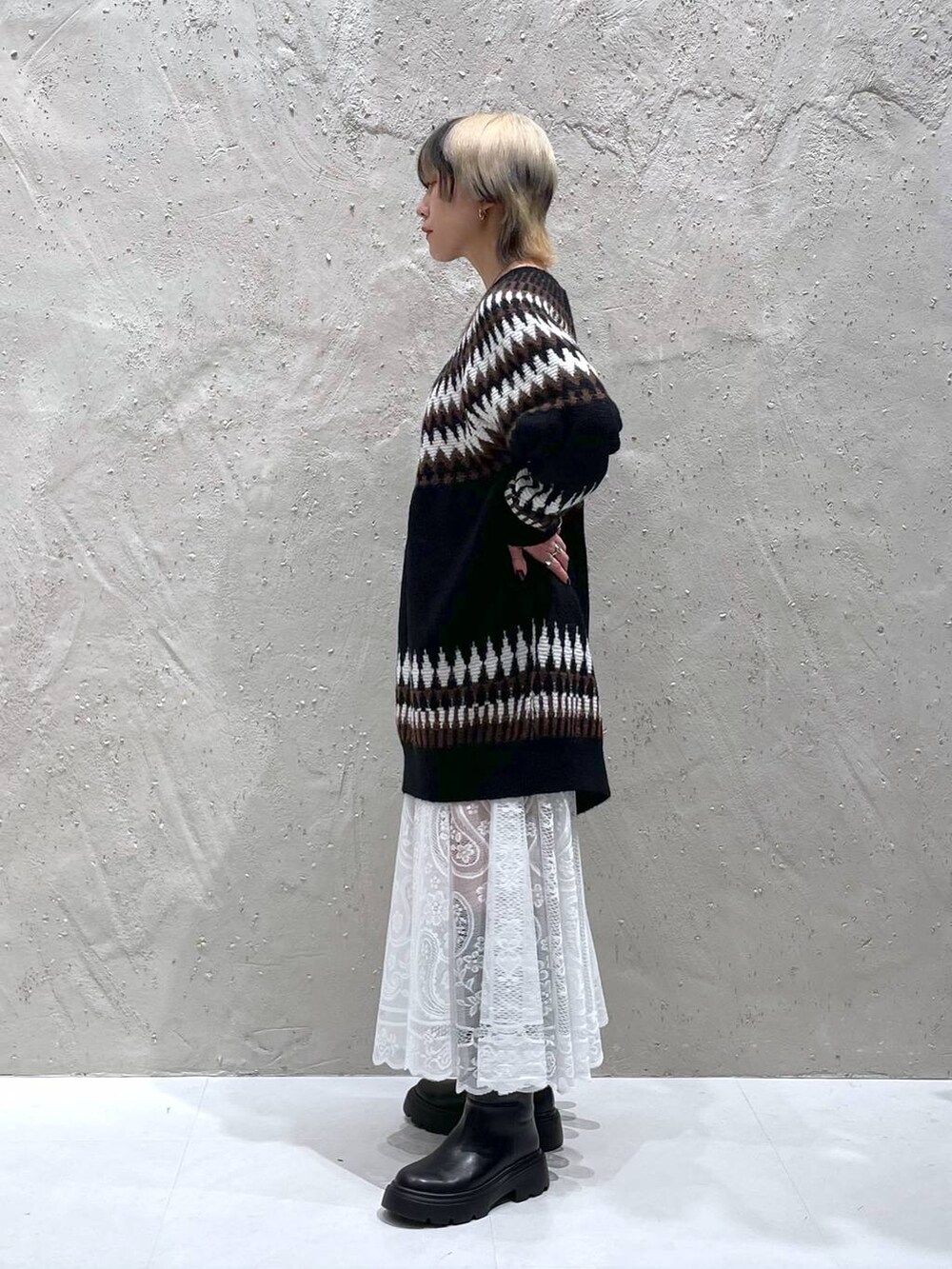 ホワイト系のスカート、ブラック系のブーツ、ブラック系のワンピースを着用したレディースの冬コーディネートの2枚目の写真