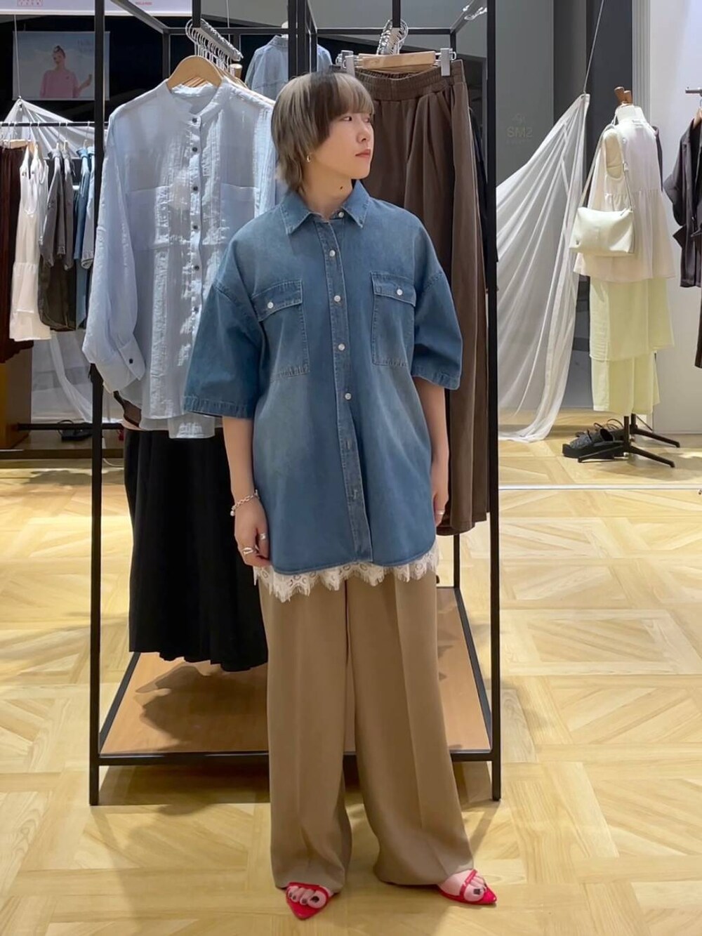 レッド系のサンダル、ブルー系のシャツ/ブラウス、ベージュ系のスラックスを着用したレディースの春コーディネートの5枚目の写真