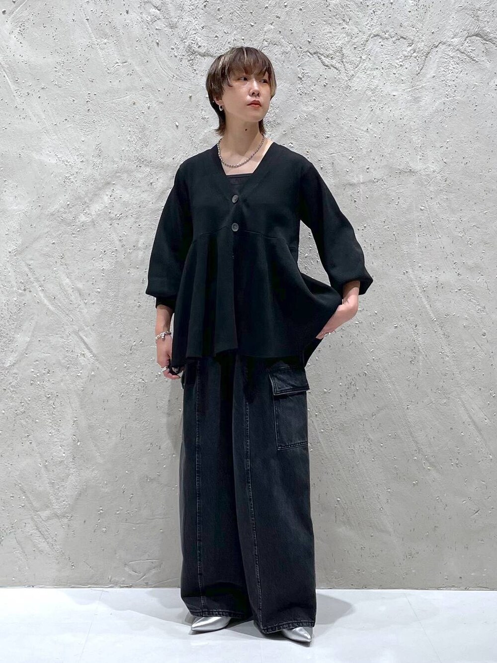 ブラック系のデニムパンツ、ブラック系のカーディガン/ボレロ、シルバー系のブーツを着用したレディースの秋コーディネートの5枚目の写真