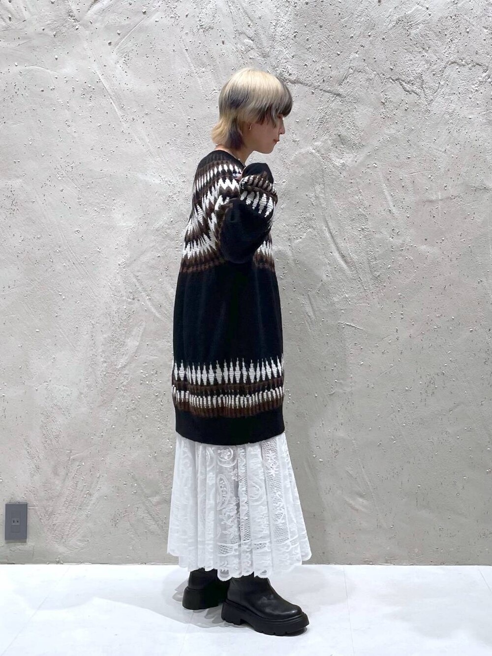 ホワイト系のスカート、ブラック系のブーツ、ブラック系のワンピースを着用したレディースの冬コーディネートの4枚目の写真