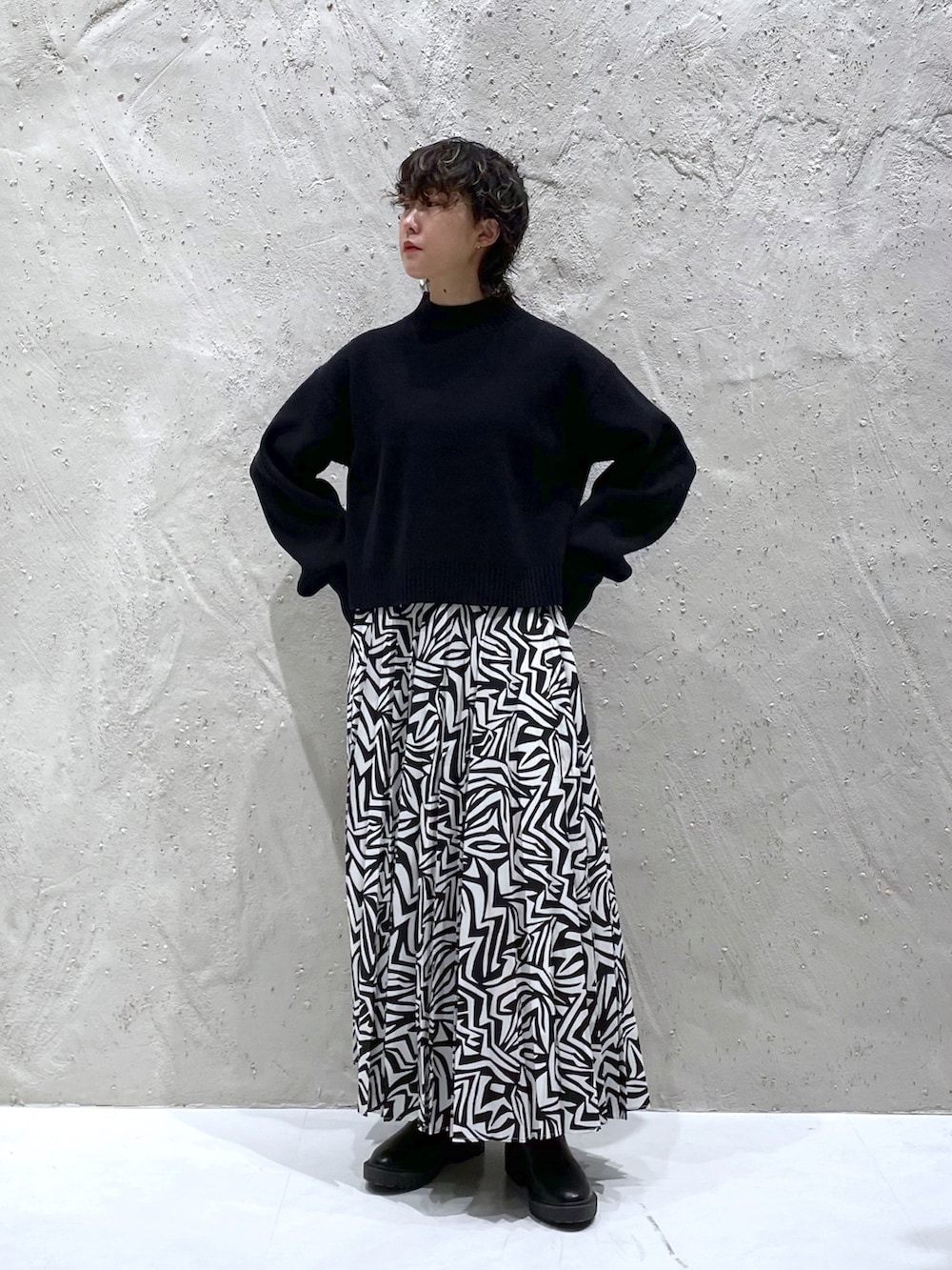 ブラック系のワンピース、ブラック系のスカート、ブラック系のブーツを着用したレディースの冬コーディネートの3枚目の写真