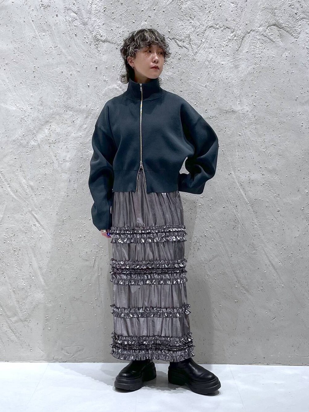 グリーン系のテーラードジャケット、シルバー系のスカート、グレー系のニット/セーターを着用したレディースの春コーディネートの6枚目の写真