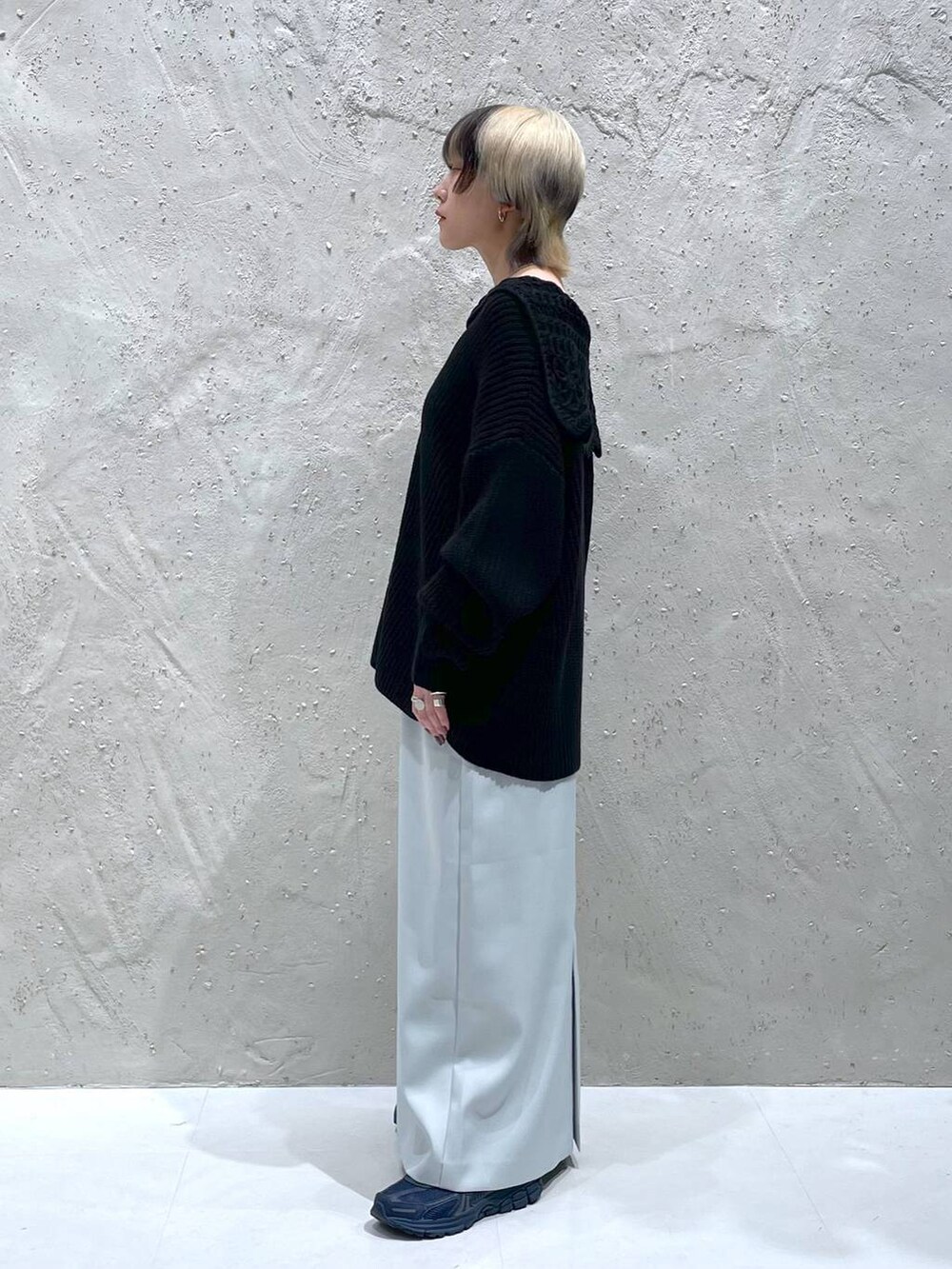 ブルー系のスカート、ブラック系のニット/セーターを着用したレディースの秋コーディネートの2枚目の写真