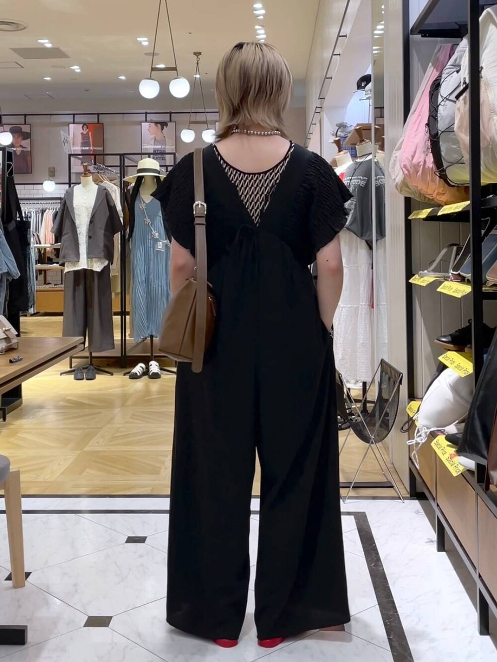 レッド系のサンダル、ブラック系のサロペット/オーバーオール、ブラウン系のショルダーバッグを着用したレディースの春コーディネートの3枚目の写真