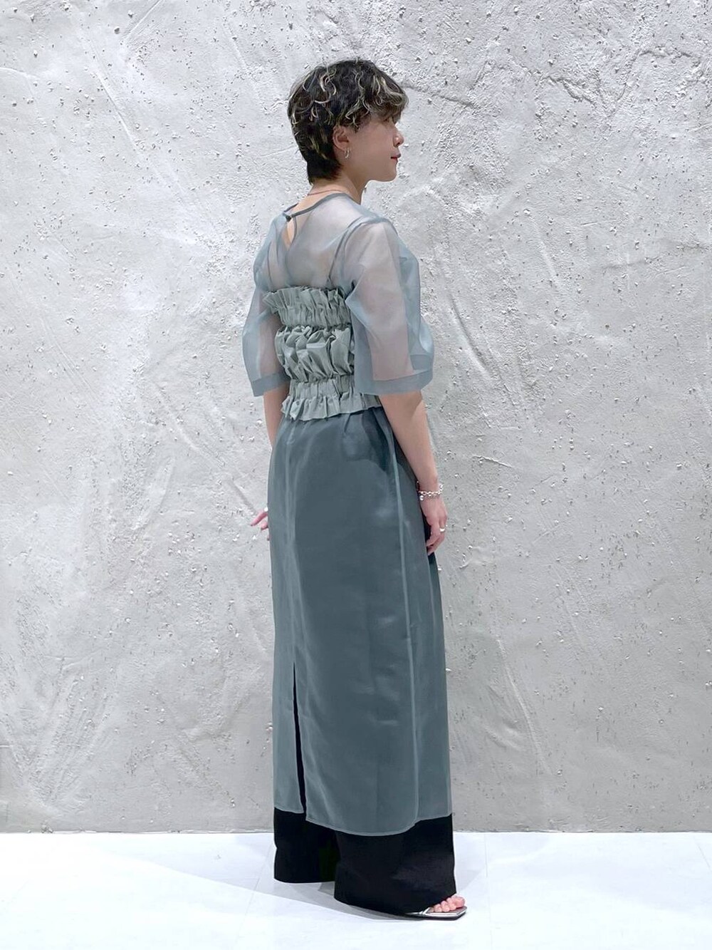 ブラック系のその他パンツ、グリーン系のワンピース、シルバー系のサンダルを着用したレディースの春コーディネートの6枚目の写真