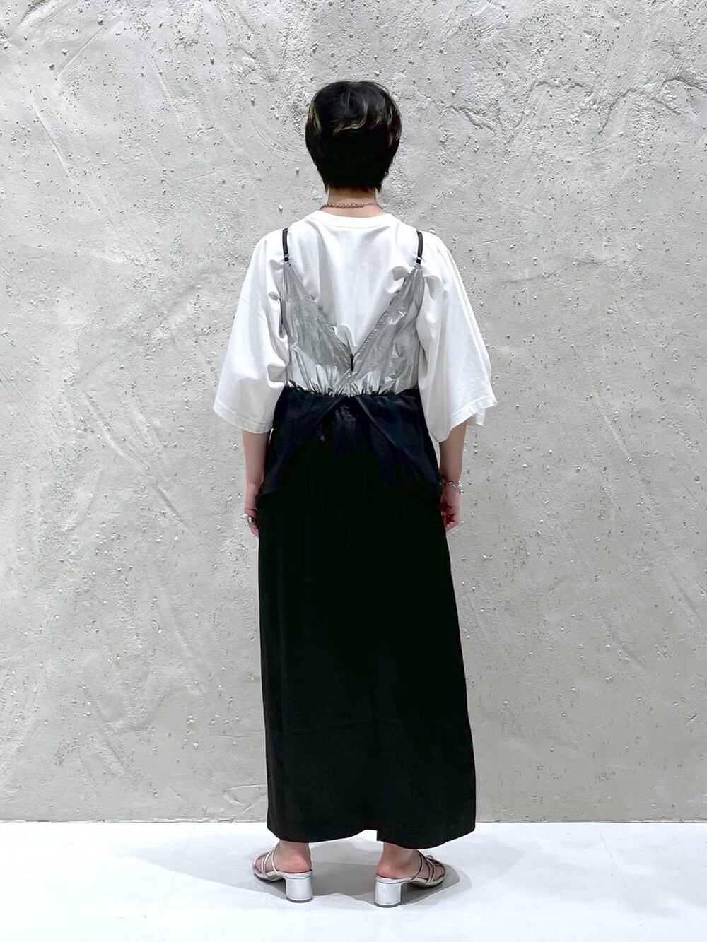 シルバー系のサンダル、ホワイト系のTシャツ/カットソー、ブラック系のワンピースを着用したレディースの春コーディネートの3枚目の写真