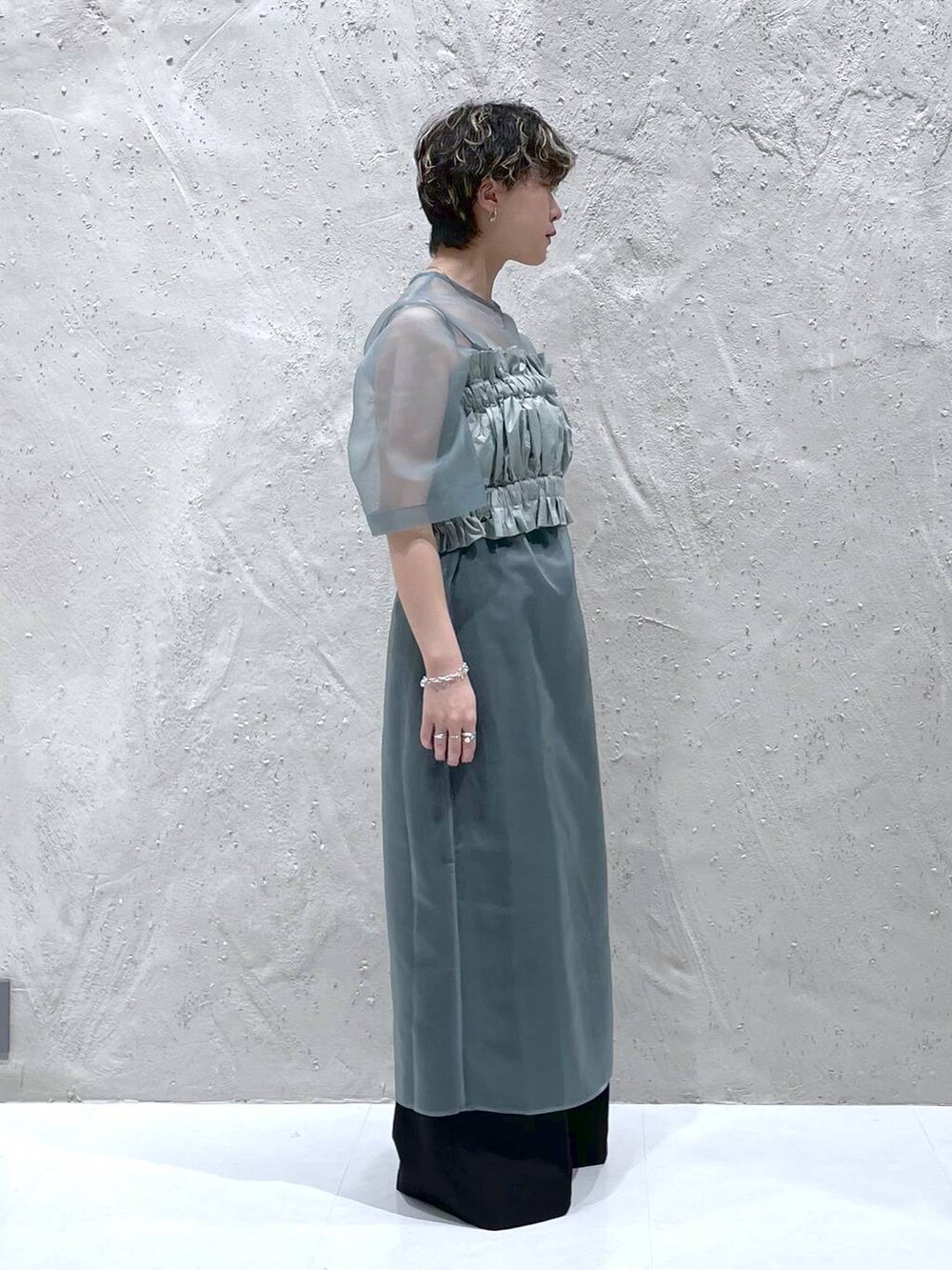 ブラック系のその他パンツ、グリーン系のワンピース、シルバー系のサンダルを着用したレディースの春コーディネートの4枚目の写真