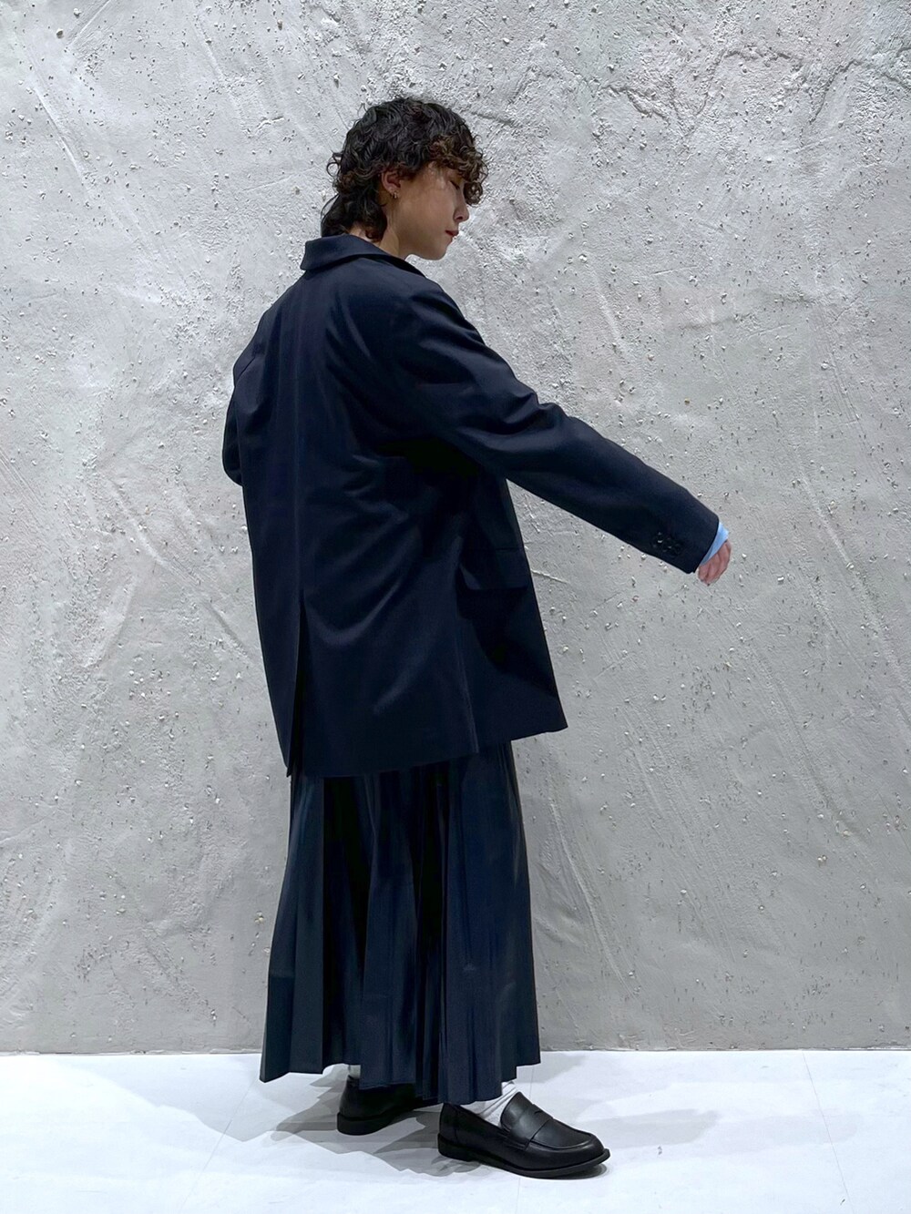 ブルー系のテーラードジャケット、ブルー系のTシャツ/カットソー、ブルー系のスカートを着用したレディースの冬コーディネートの2枚目の写真