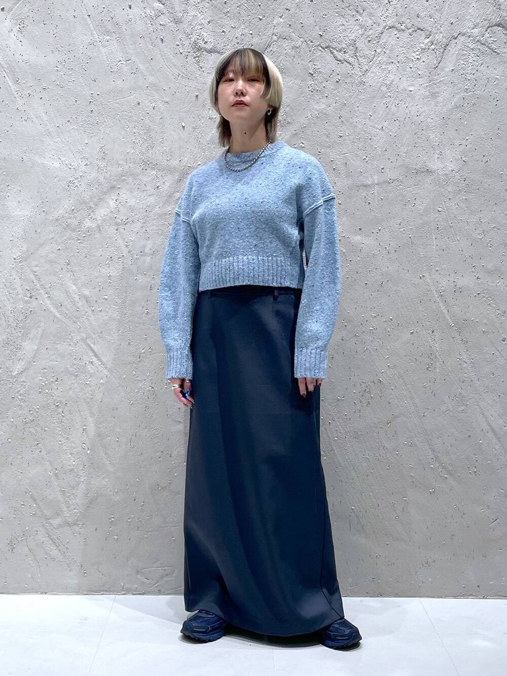 ブルー系のニット/セーター、グリーン系のスカートを着用したレディースの冬コーディネートの5枚目の写真