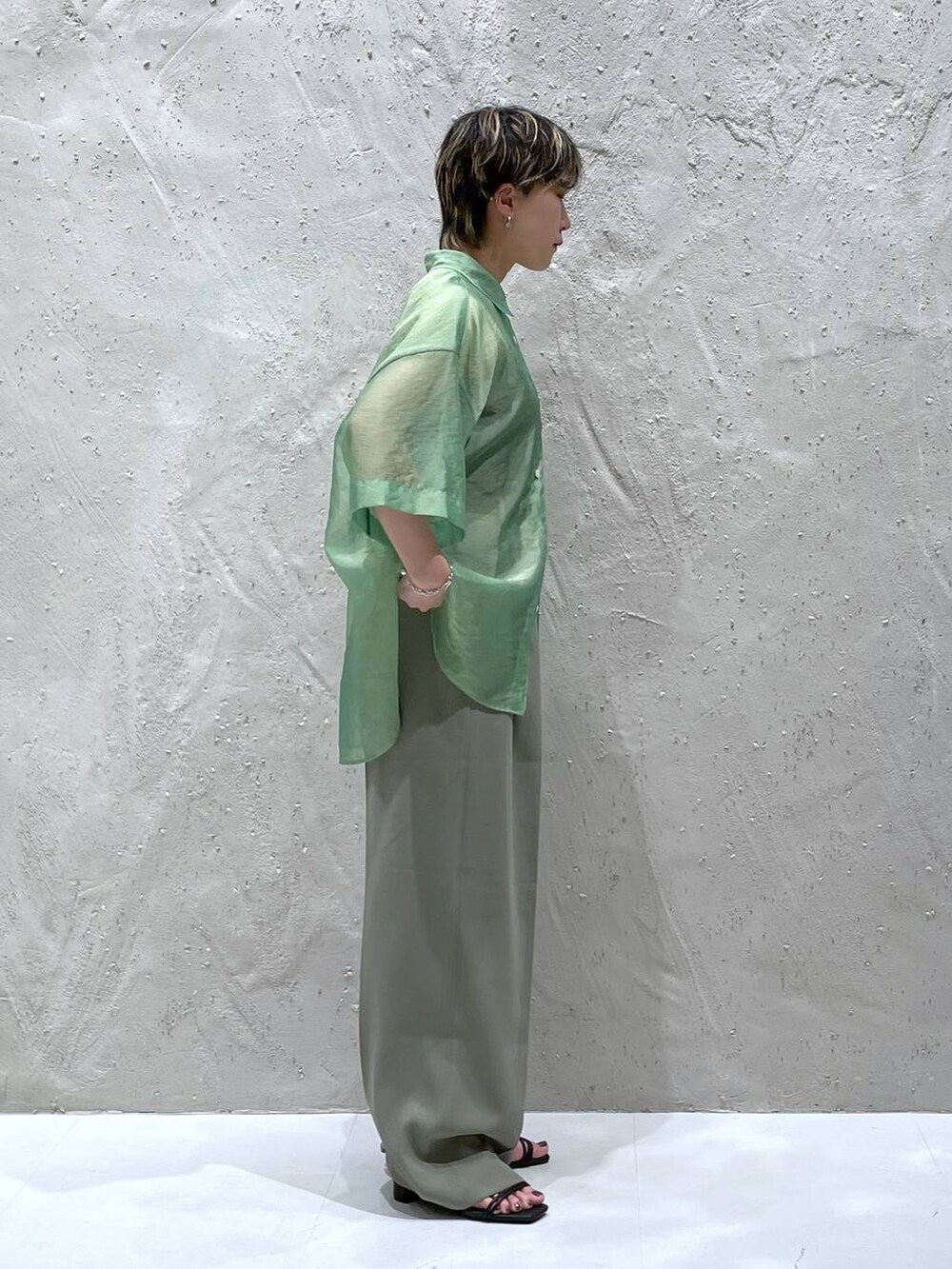 グリーン系のスラックス、グリーン系のシャツ/ブラウス、ブラック系のサンダルを着用したレディースの夏コーディネートの3枚目の写真