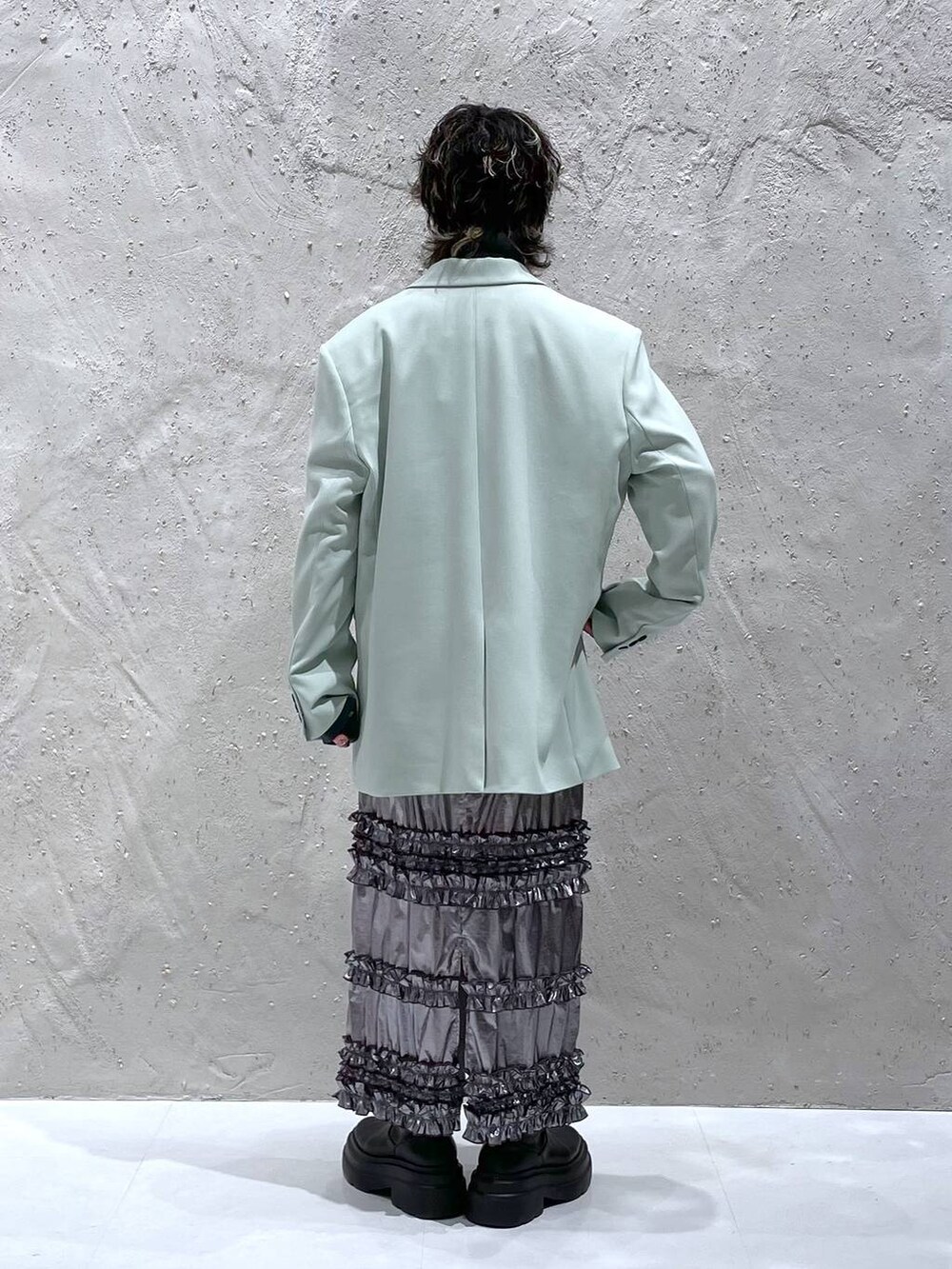 グリーン系のテーラードジャケット、シルバー系のスカート、グレー系のニット/セーターを着用したレディースの春コーディネートの3枚目の写真