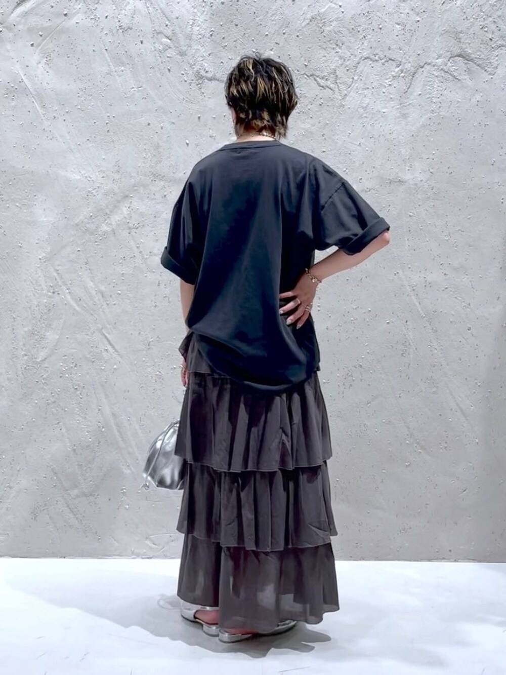 シルバー系のパンプス、シルバー系のショルダーバッグ、ブラック系のTシャツ/カットソーを着用したレディースの夏コーディネートの3枚目の写真