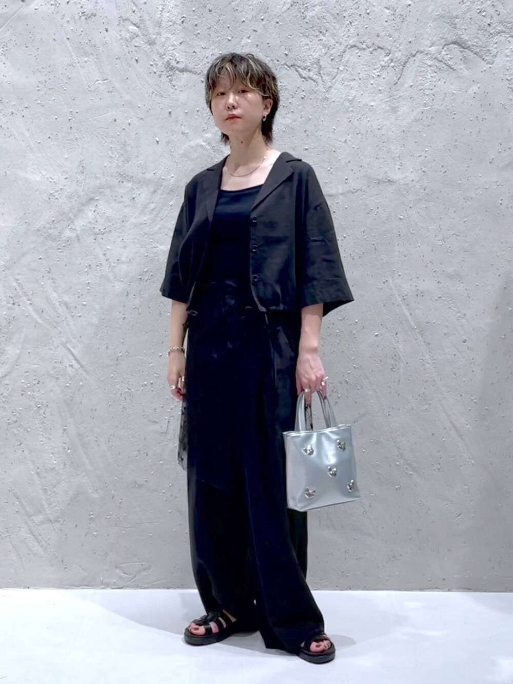 ブラック系のTシャツ/カットソー、ブラック系のスニーカー、グレー系のスラックスを着用したレディースの夏コーディネートの5枚目の写真