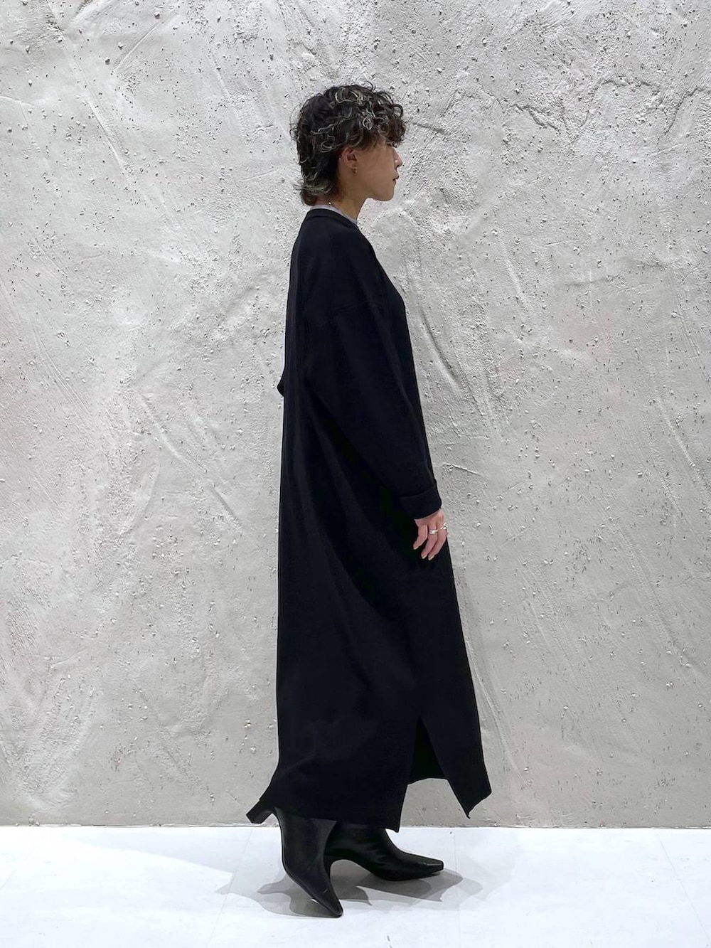 ブラック系のブーツ、ブラック系のワンピースを着用したレディースの秋コーディネートの2枚目の写真