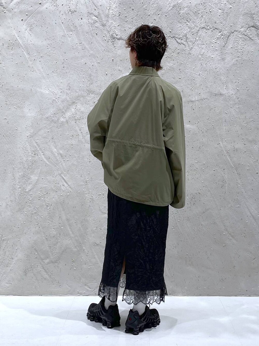 グリーン系のブルゾン、ブラック系のスカートを着用したレディースの夏コーディネートの3枚目の写真