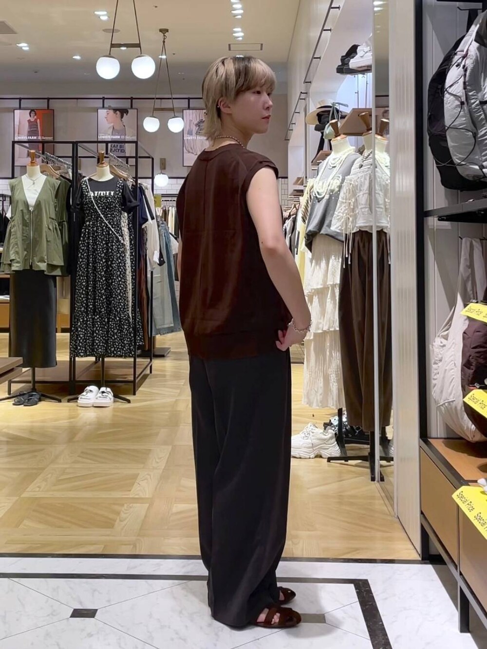 グレー系のテーラードジャケット、グレー系のスラックス、ブラウン系のサンダルを着用したレディースの夏コーディネートの7枚目の写真