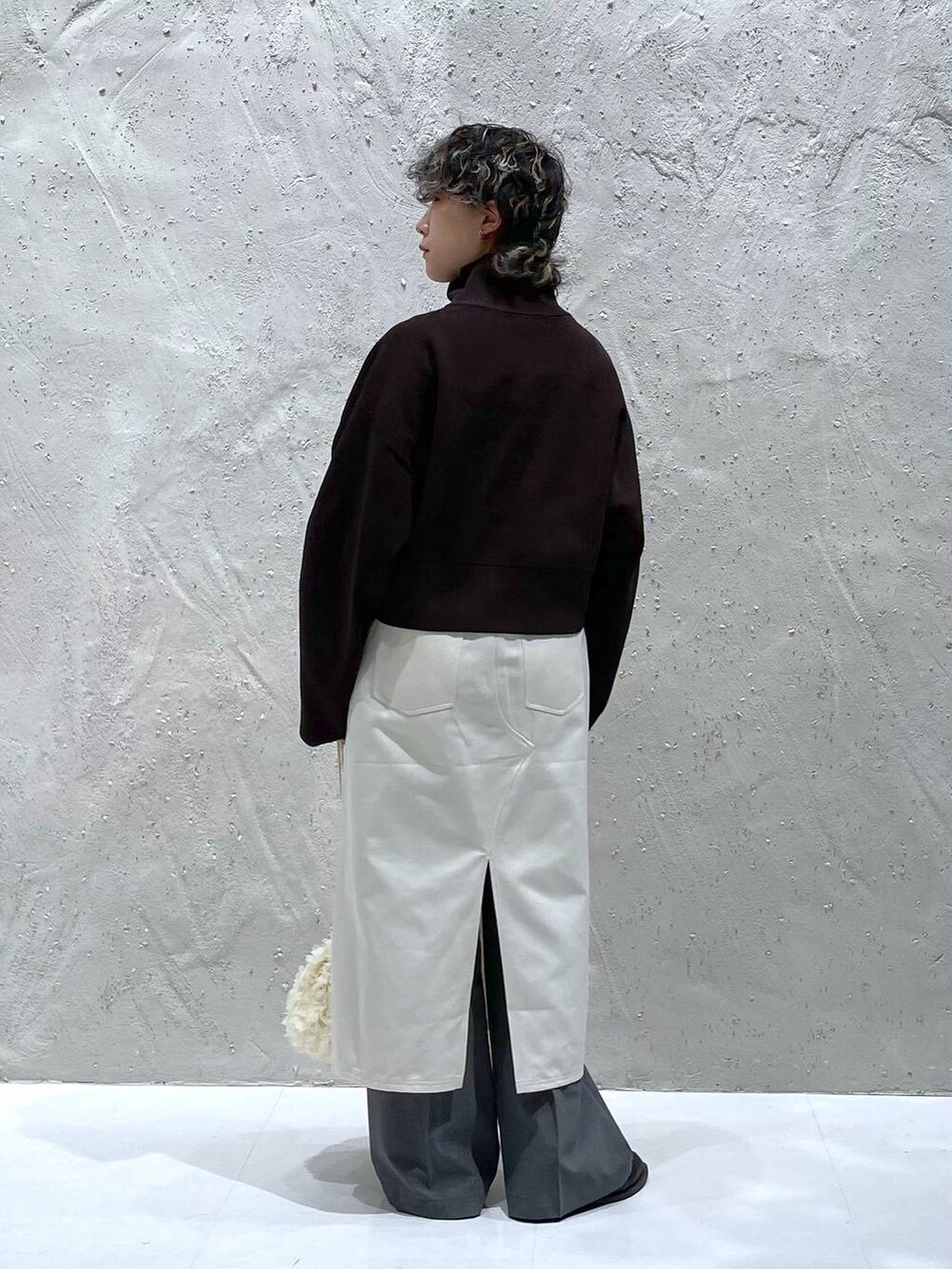 グレー系のその他パンツ、ベージュ系のスカート、ホワイト系のハンドバッグを着用したレディースの春コーディネートの3枚目の写真