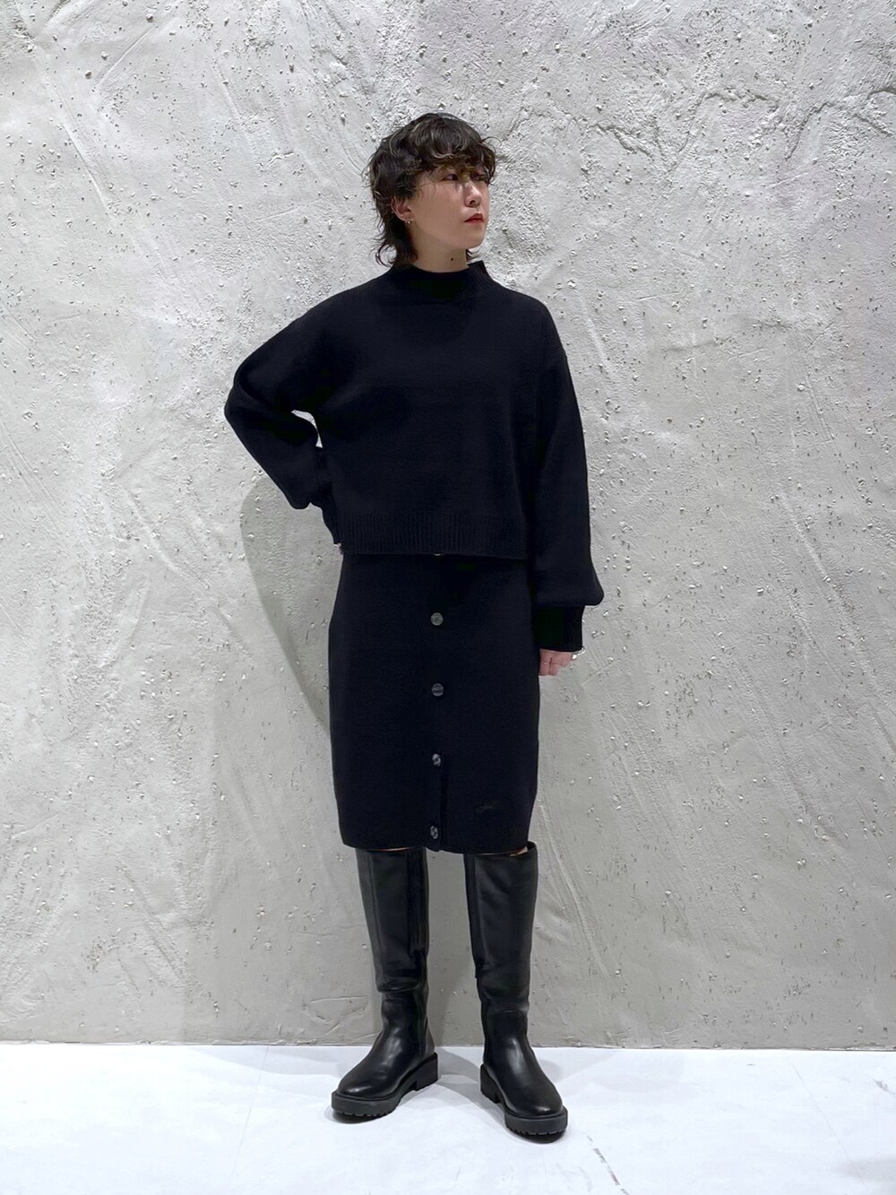 ブラック系のワンピース、ブラック系のスカート、ブラック系のブーツを着用したレディースの冬コーディネートの5枚目の写真