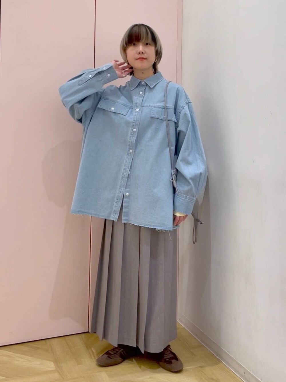 ブラウン系のスニーカー、グレー系のバックパック/リュック、ブルー系のシャツ/ブラウスを着用したレディースの冬コーディネートの4枚目の写真