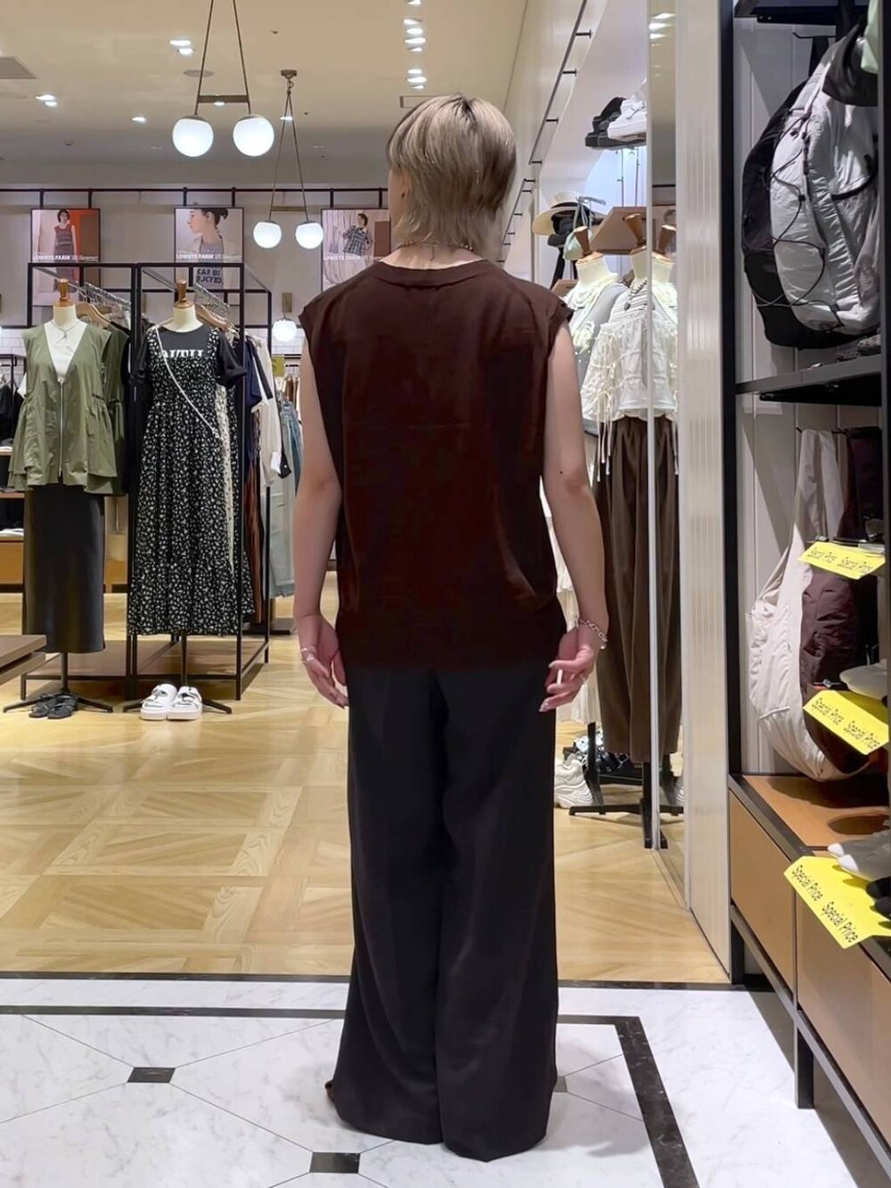 グレー系のテーラードジャケット、グレー系のスラックス、ブラウン系のサンダルを着用したレディースの夏コーディネートの8枚目の写真