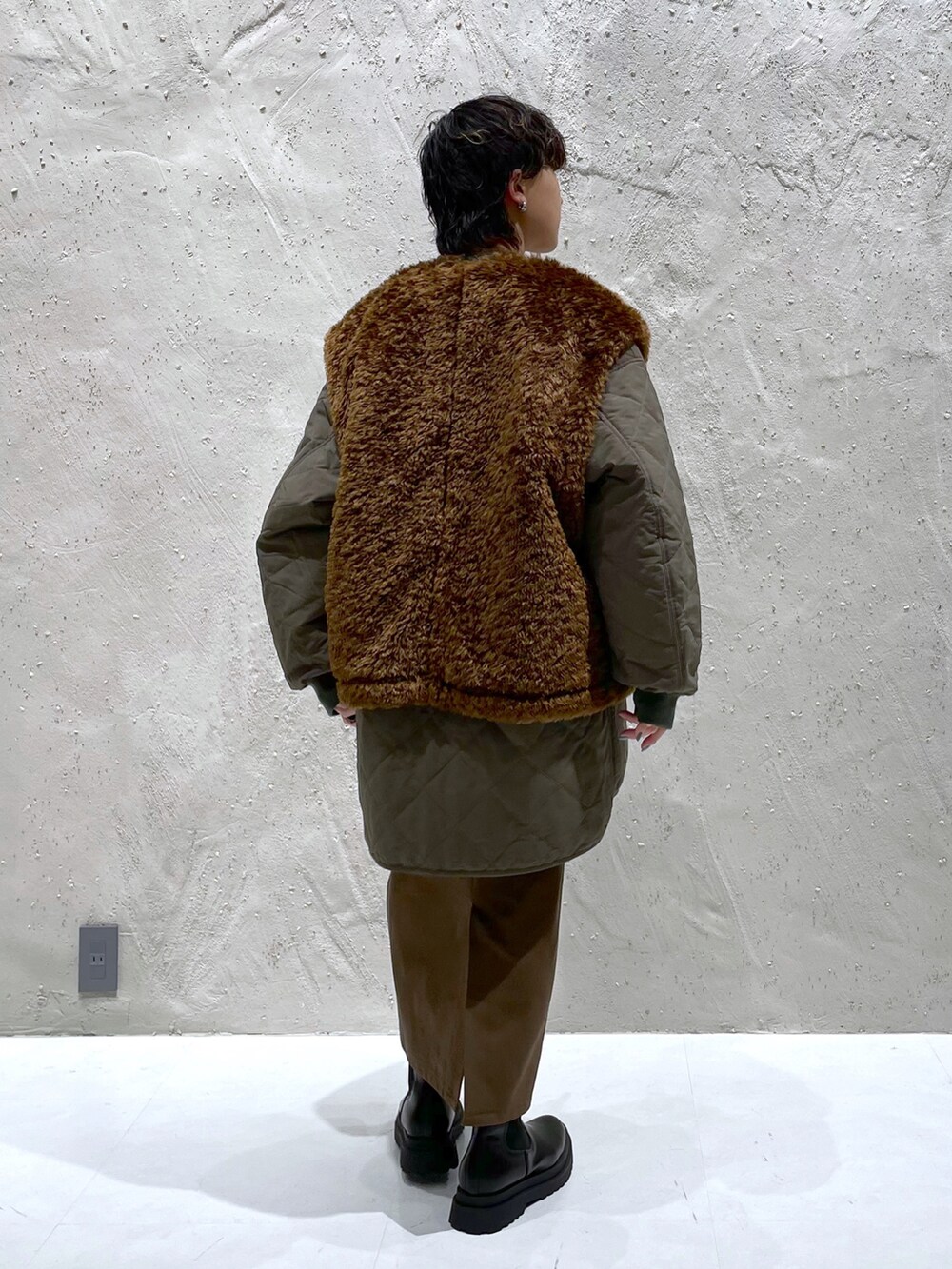 ブルー系のスウェット、グリーン系のブルゾン、ブラック系のブーツを着用したレディースの冬コーディネートの3枚目の写真