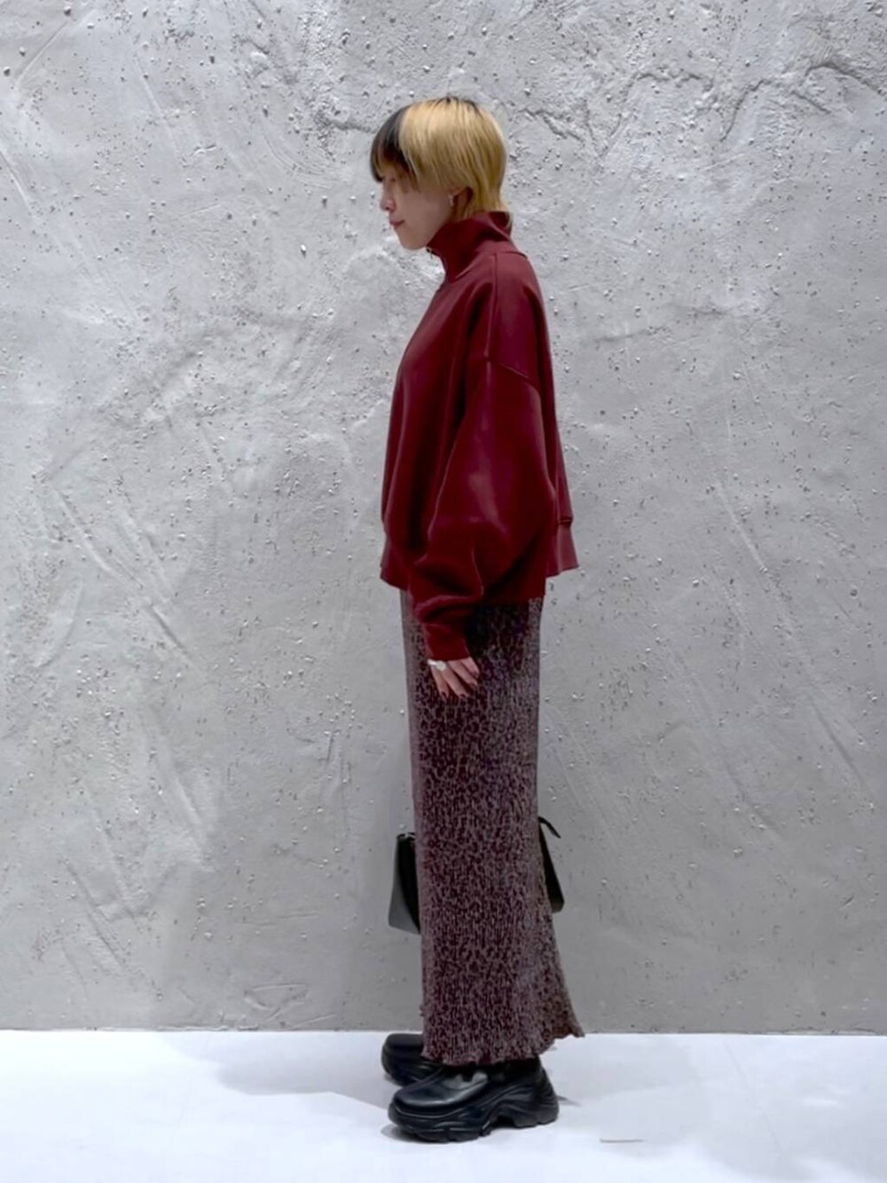 ブラック系のブーツ、ブラック系のショルダーバッグ、その他のスカートを着用したレディースの秋コーディネートの2枚目の写真