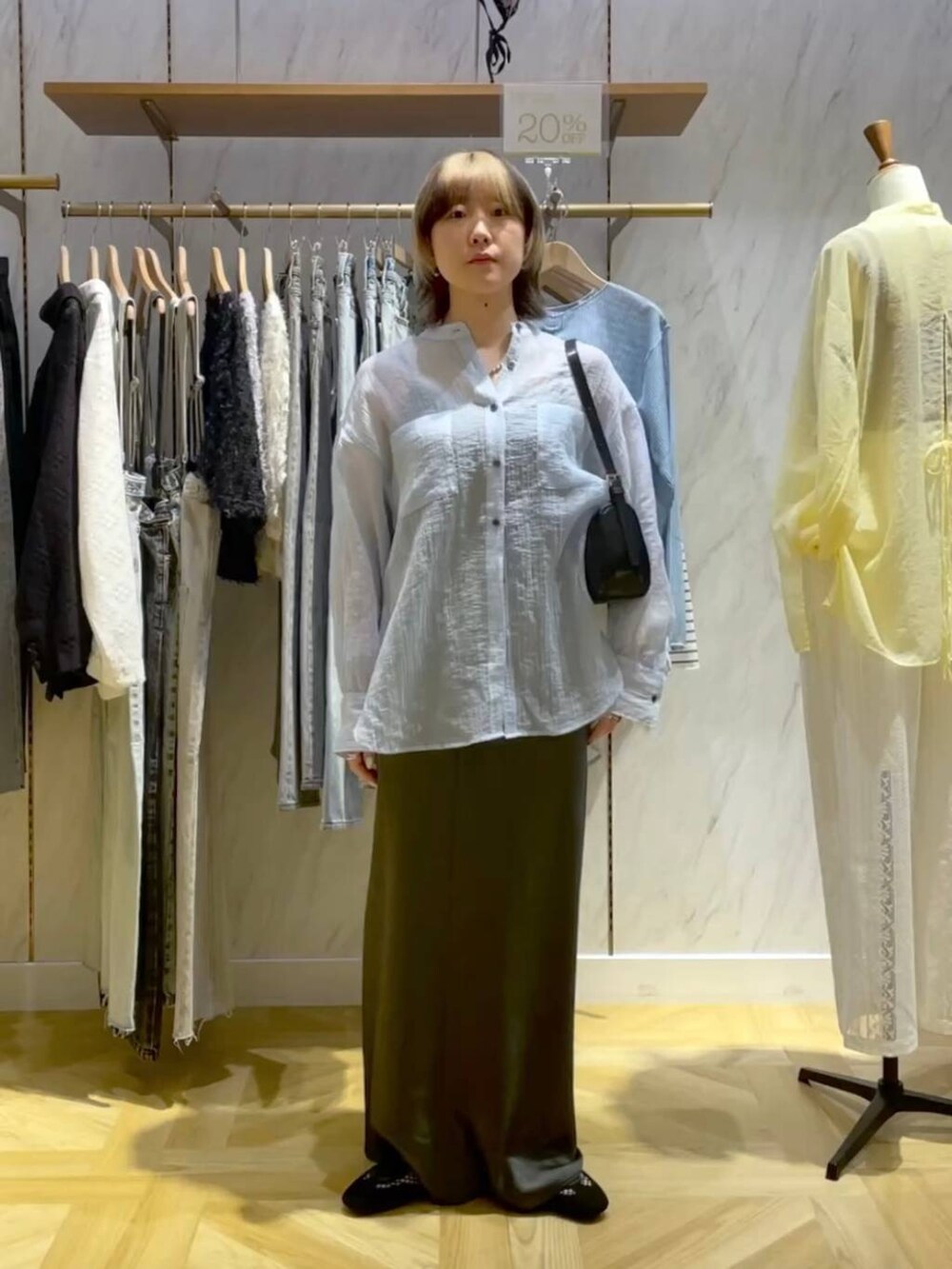 ブラック系のトートバッグ、ブラック系のスニーカー、グレー系のスカートを着用したレディースの春コーディネートの5枚目の写真