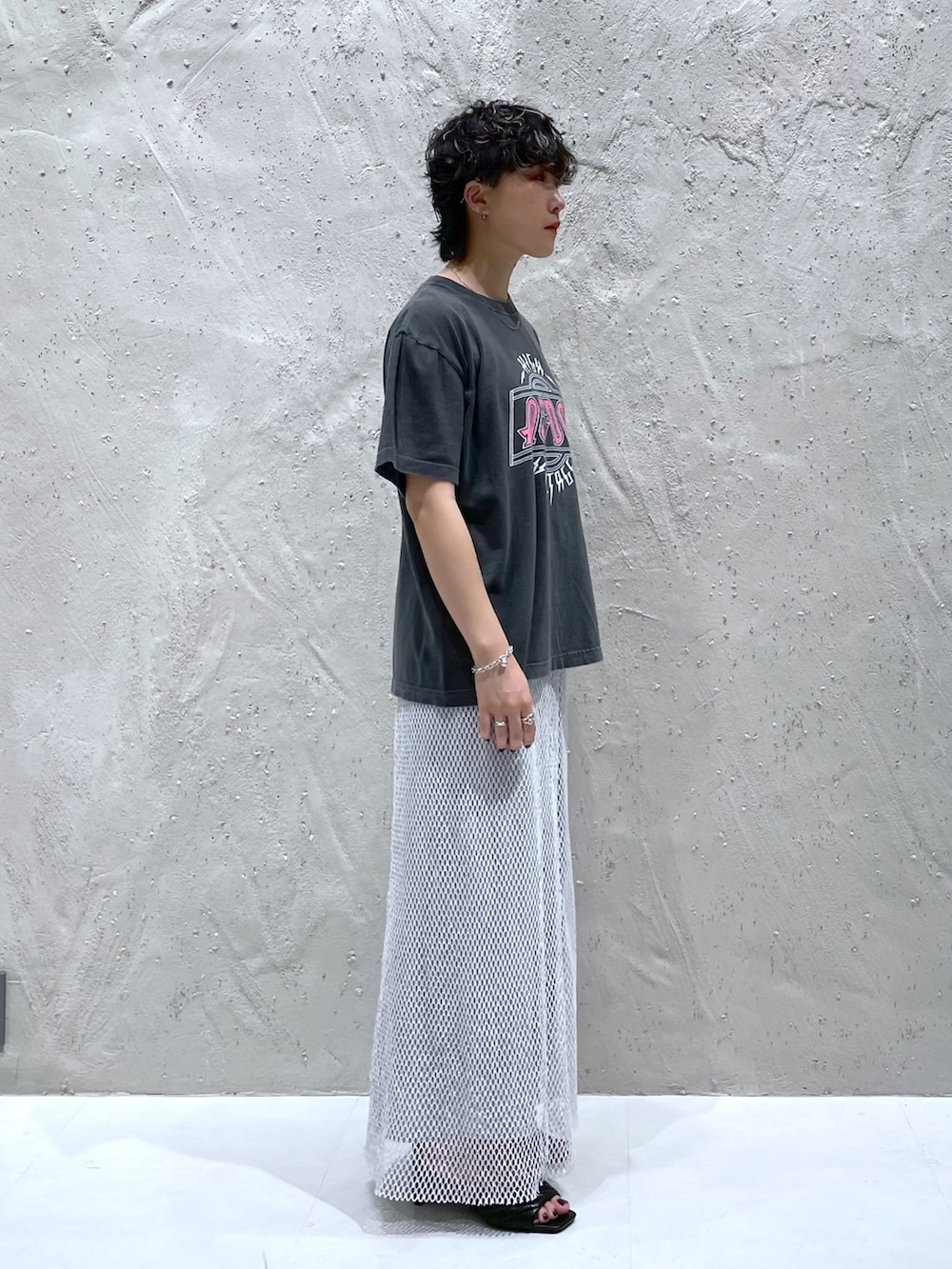 グレー系のTシャツ/カットソー、ホワイト系のスカート、ブラック系のサンダルを着用したレディースの夏コーディネートの3枚目の写真