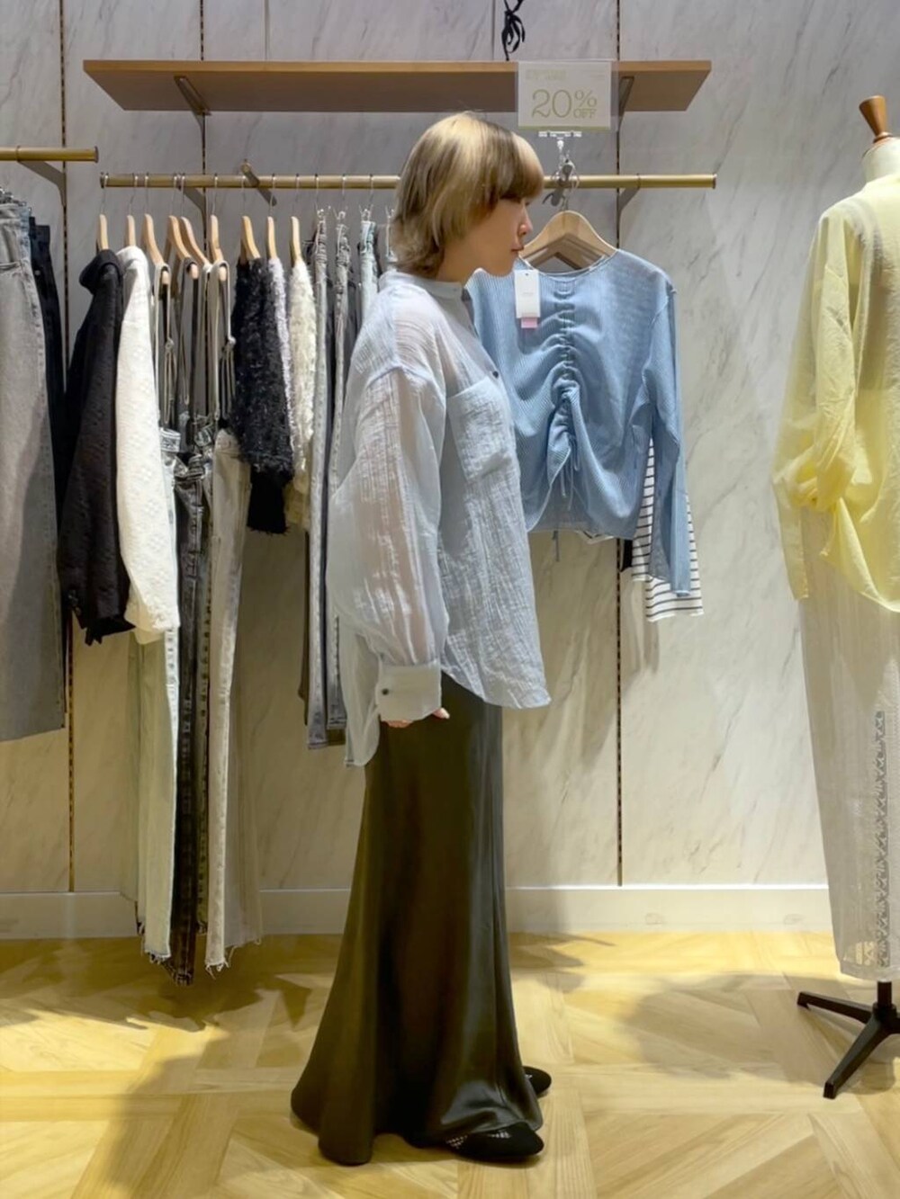 ブラック系のトートバッグ、ブラック系のスニーカー、グレー系のスカートを着用したレディースの春コーディネートの4枚目の写真