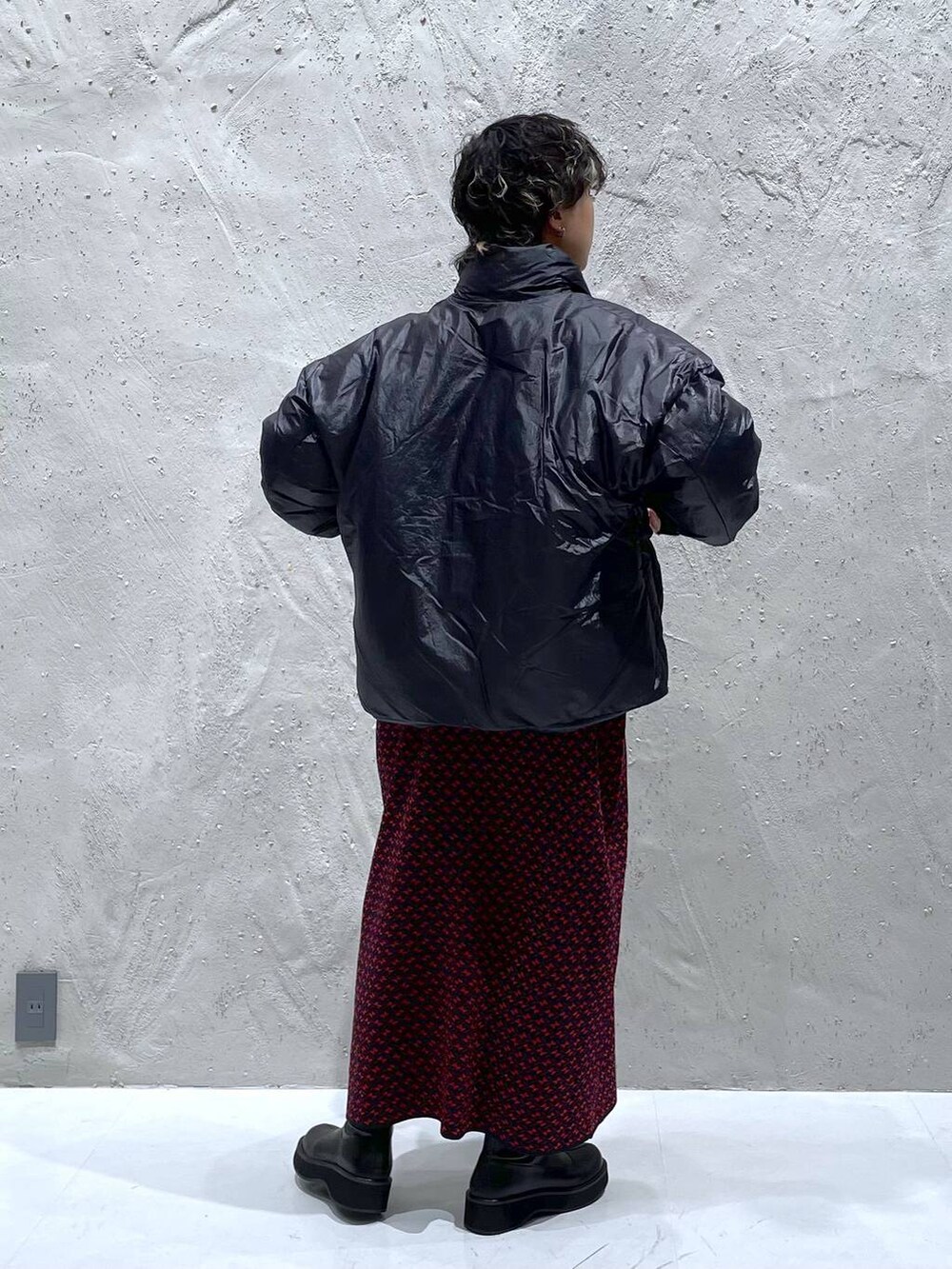 ブラック系のブーツ、ブラック系のダウンジャケット/コート、レッド系のワンピースを着用したレディースの秋コーディネートの3枚目の写真