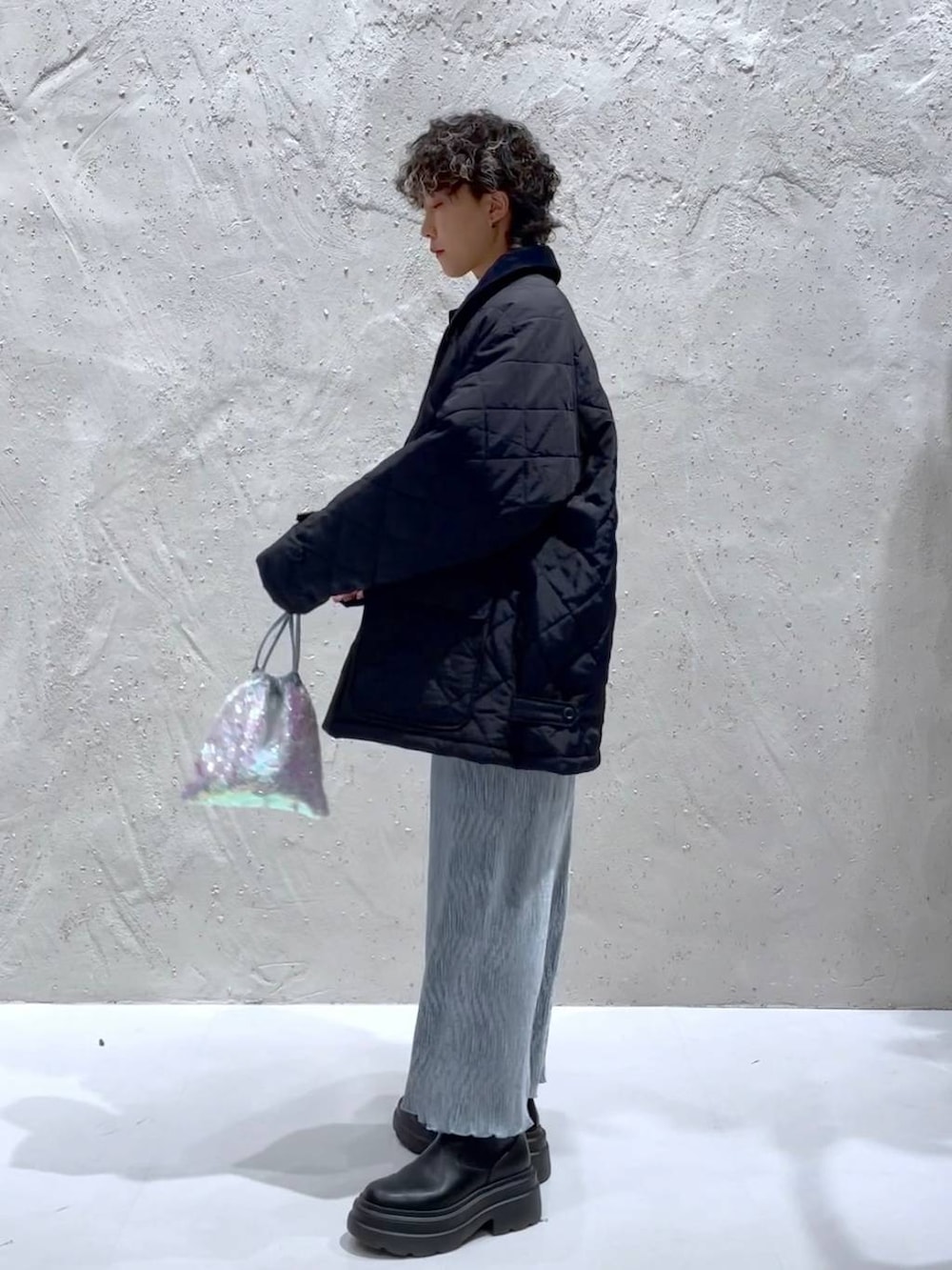 ブルー系のTシャツ/カットソー、ブラック系のブーツ、ホワイト系のハンドバッグを着用したレディースの冬コーディネートの2枚目の写真