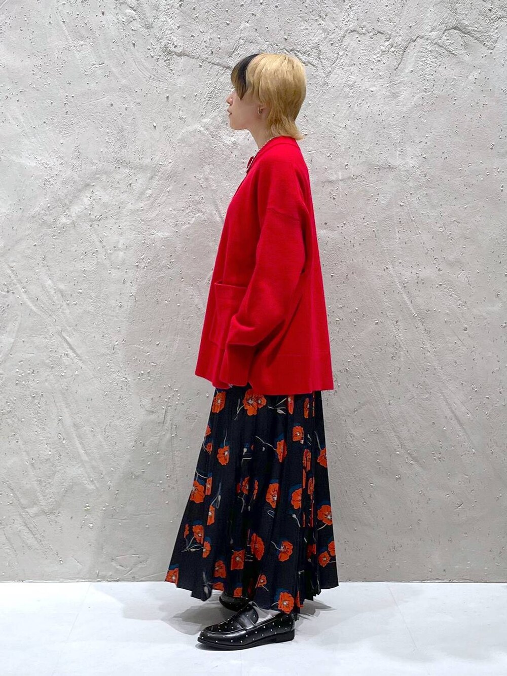 ブラック系のローファー、レッド系のニット/セーター、その他のスカートを着用したレディースの秋コーディネートの2枚目の写真