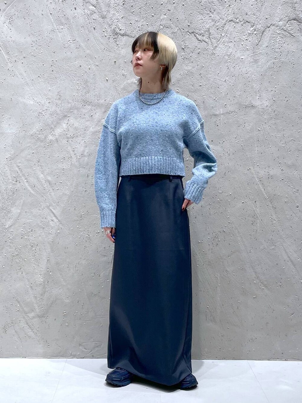 ブルー系のニット/セーター、グリーン系のスカートを着用したレディースの冬コーディネートの6枚目の写真