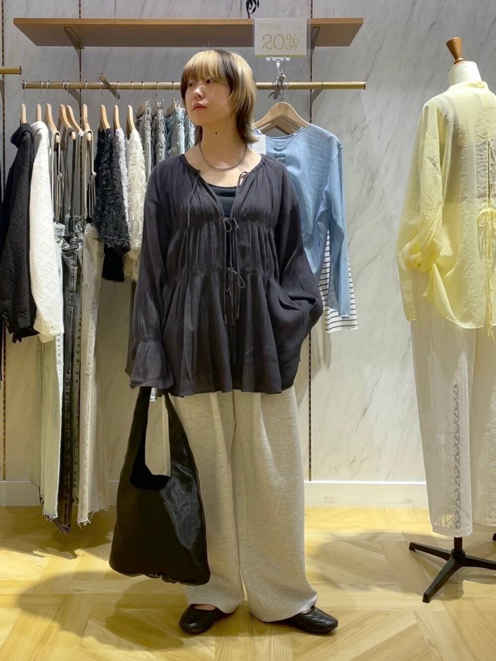 グレー系のシャツ/ブラウス、ブラック系のスニーカー、グレー系のスウェットパンツを着用したレディースの春コーディネートの5枚目の写真