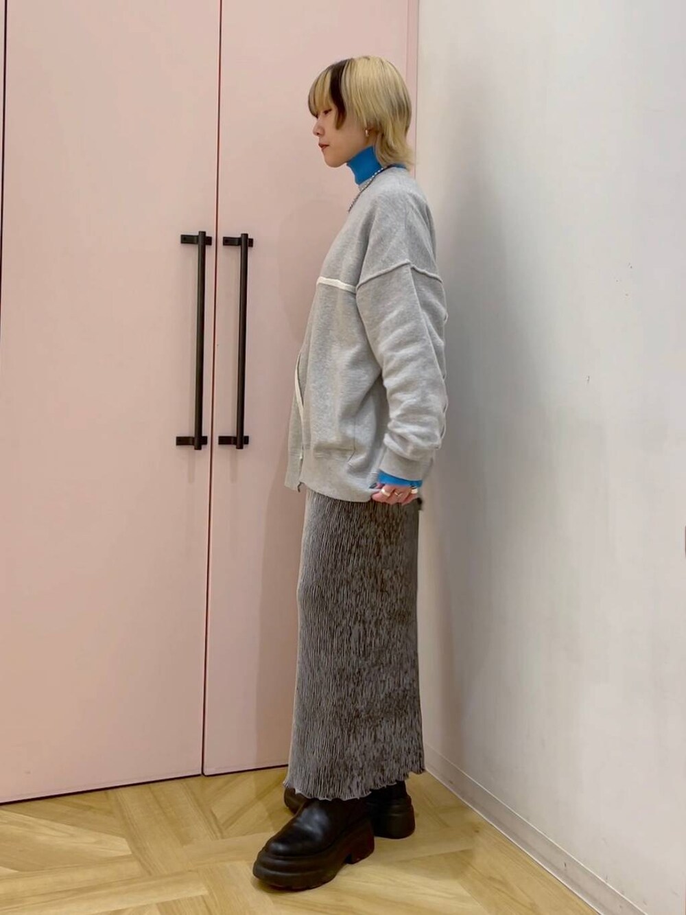 ブルー系のニット/セーター、グレー系のスカート、グレー系のスウェットを着用したレディースの冬コーディネートの2枚目の写真