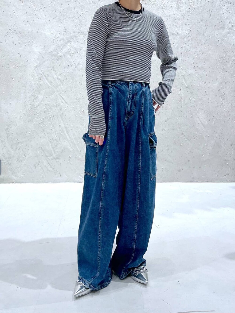 ブルー系のデニムパンツ、シルバー系のパンプス、その他のニット/セーターを着用したレディースの夏コーディネートの5枚目の写真