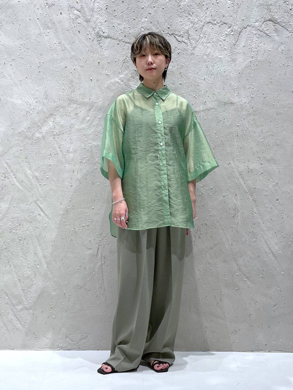 グリーン系のスラックス、グリーン系のシャツ/ブラウス、ブラック系のサンダルを着用したレディースの夏コーディネートの4枚目の写真